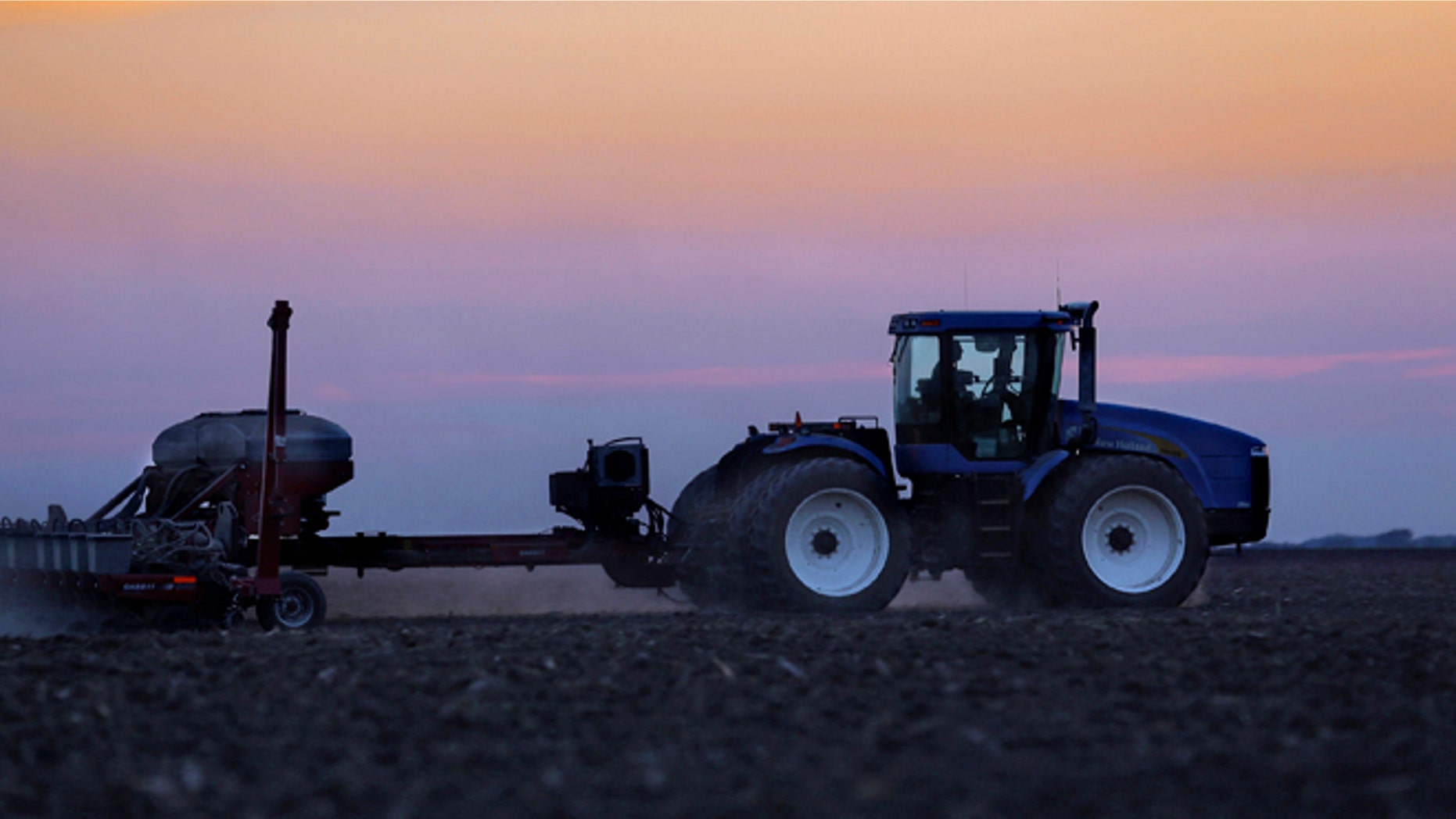 In this Saturday, June 8, 2013 photo, a central Illinois farmer continues planting corn seed into the evening in Farmingdale, Ill.