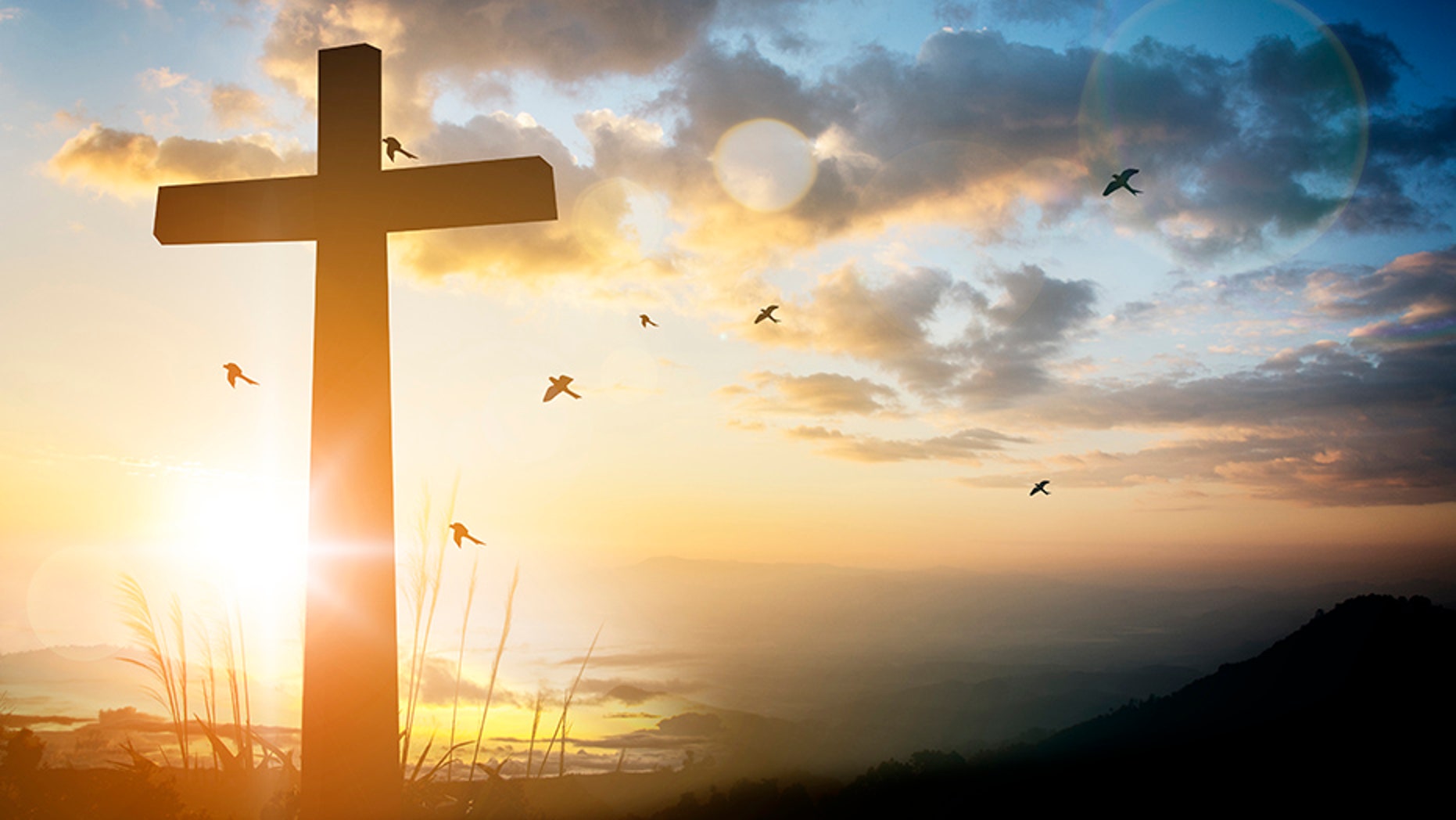 cross on blurry sunset background .