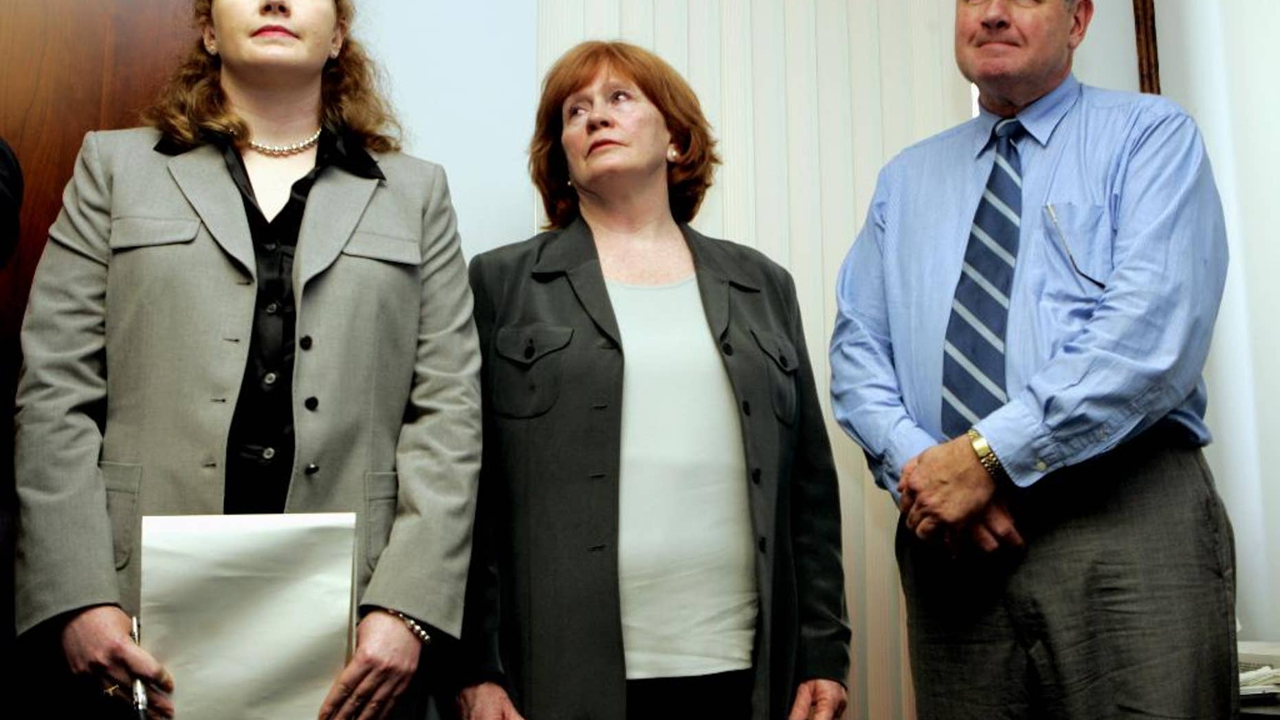 FILE - In this Dec. 9, 2005, file photo, Bree Smith, left, stands with her mother and father Maureen and George Smith while their attorney makes a statement during a news conference in Miami, regarding the disappearance of her brother and their son, George Smith IV. FBI officials have told relatives George Smith IV who disappeared during his honeymoon cruise in 2005 that they have ended their investigation of the case, the family's lawyer said Thursday, Jan. 8, 2015. (AP Photo/ Lynne Sladky, File)