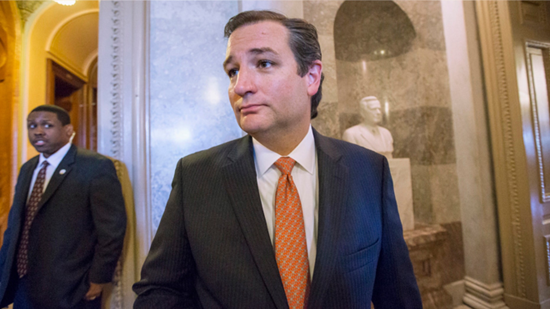 Sen. Ted Cruz, R-Texas leaves the floor of the Senate on Capitol Hill in Washington, Monday, Sept. 23, 2013, after a testy exchange with Senate Majority Leader Harry Reid, D-Nev., at the start of legislative business. Cruz and fellow tea party conservatives on Sunday said President Barack Obama and his Democratic allies would be to blame if they don't accede to GOP demands to strike down the national health care law. Conservatives in the House on Friday approved legislation to keep the government running but at the cost of wiping out the Affordable Care Act, popularly known at "Obamacare." (AP Photo/J. Scott Applewhite)