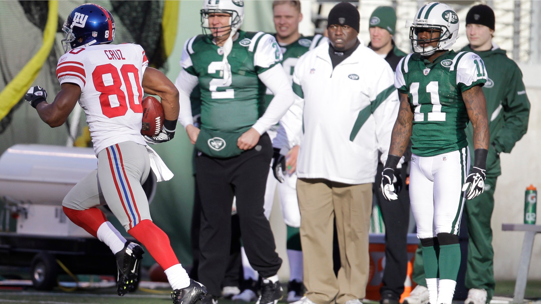 New York Giants' Victor Cruz (80) runs 99 yards for a touchdown as the New York Jets sideline watches during the second quarter of an NFL football game between the New York Giants and the New York Jets, Saturday, Dec. 24, 2011, in East Rutherford, N.J. (AP Photo/Julio Cortez)
