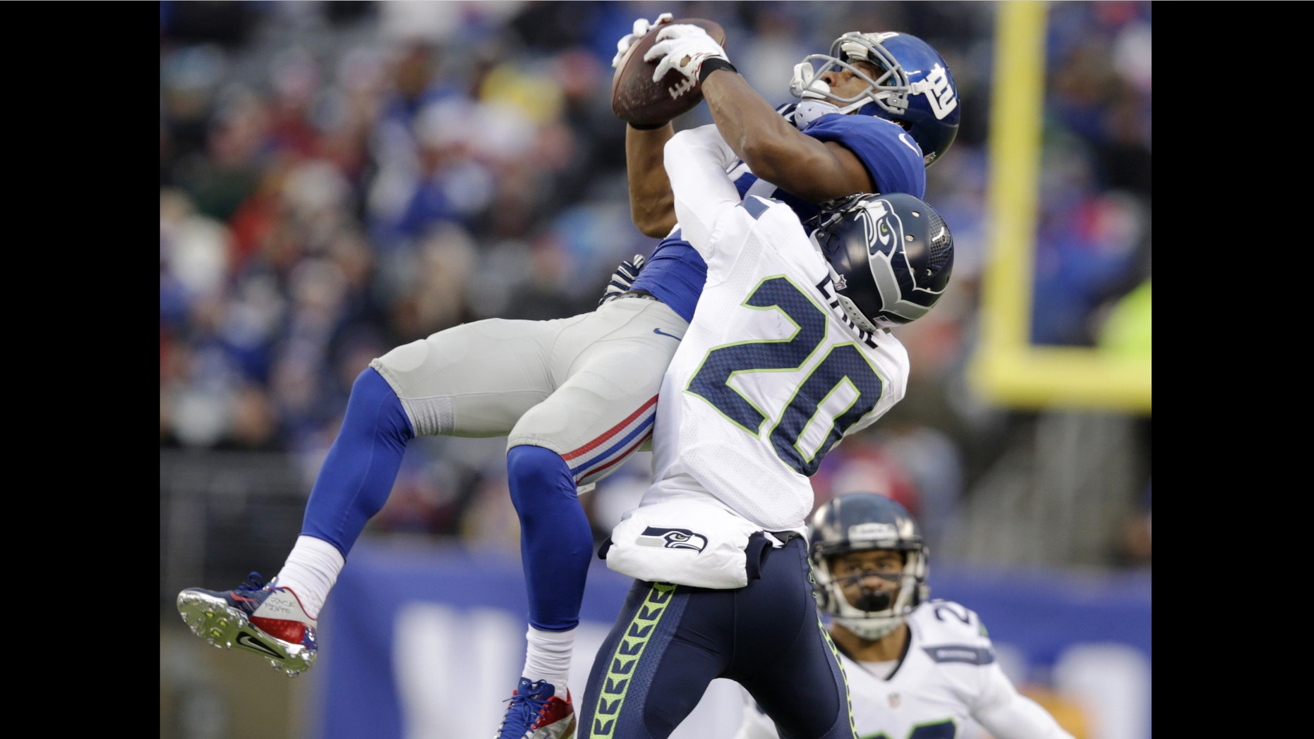 New York Giants wide receiver Victor Cruz, left, makes a catch as Seattle Seahawks cornerback Jeremy Lane defends on the play during the second half of an NFL football game, Sunday, Dec. 15, 2013, in East Rutherford, N.J. Cruz was banged up on the play and left the game with an injury. (AP Photo/Kathy Willens)