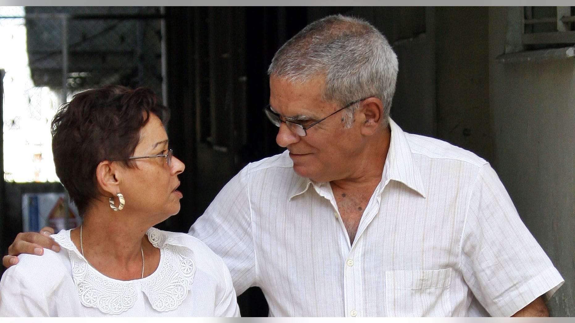 FILE - In this Nov. 29, 2004 file photo, Oscar Espinosa Chepe walks with his wife Miriam Leiva at their home after being freed on parole from prison where he was serving a twenty-year sentence, in Havana, Cuba. Due to serious liver problems, Espinosa Chepe has been on an intravenous drip at a Havana hospital for more than a week, as of Monday, Sept. 3, 2012, and unable to even drink liquids until Monday morning, according to his wife Miriam Leiva, herself a leading dissident. (AP Photo/Jose Goitia, File)