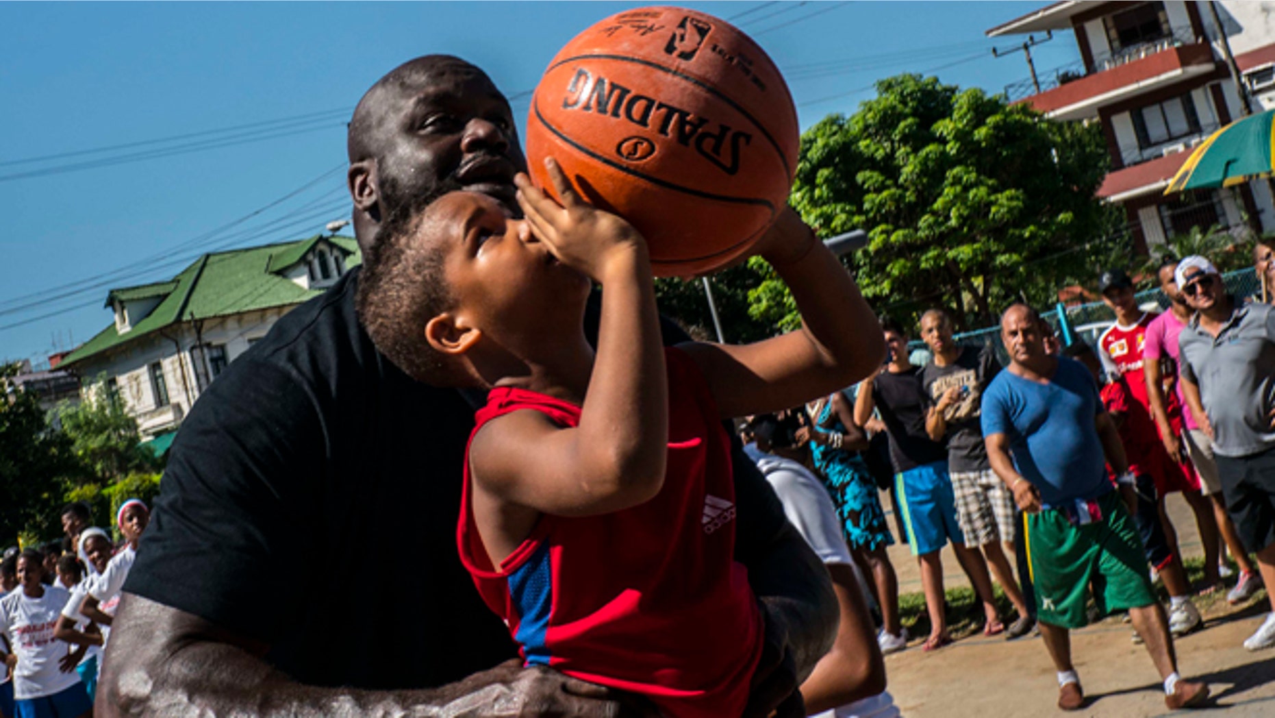 Shaquille O'Neal, plays with a youngster during a clinic with young players in Havana, Sunday, June 26, 2016.