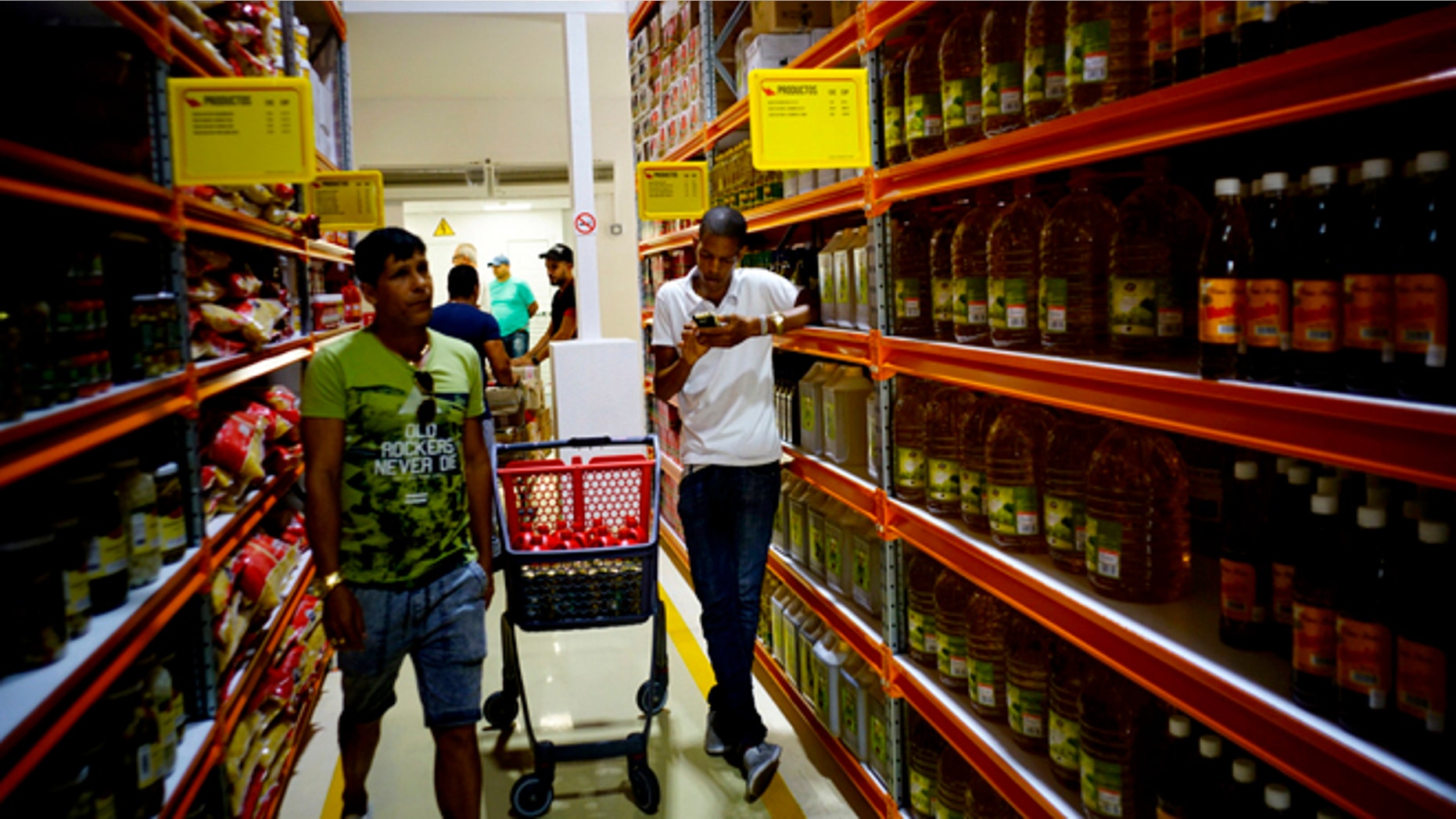 Shoppers walk through the aisles of a new bulk goods store in Havana, Cuba, Monday, July 11, 2016. Called Zona +, the high-ceiling space has racks stacked with large tins of tomato sauce, toilet paper and cooking oil by the gallon. (AP Photo/Ramon Espinosa)
