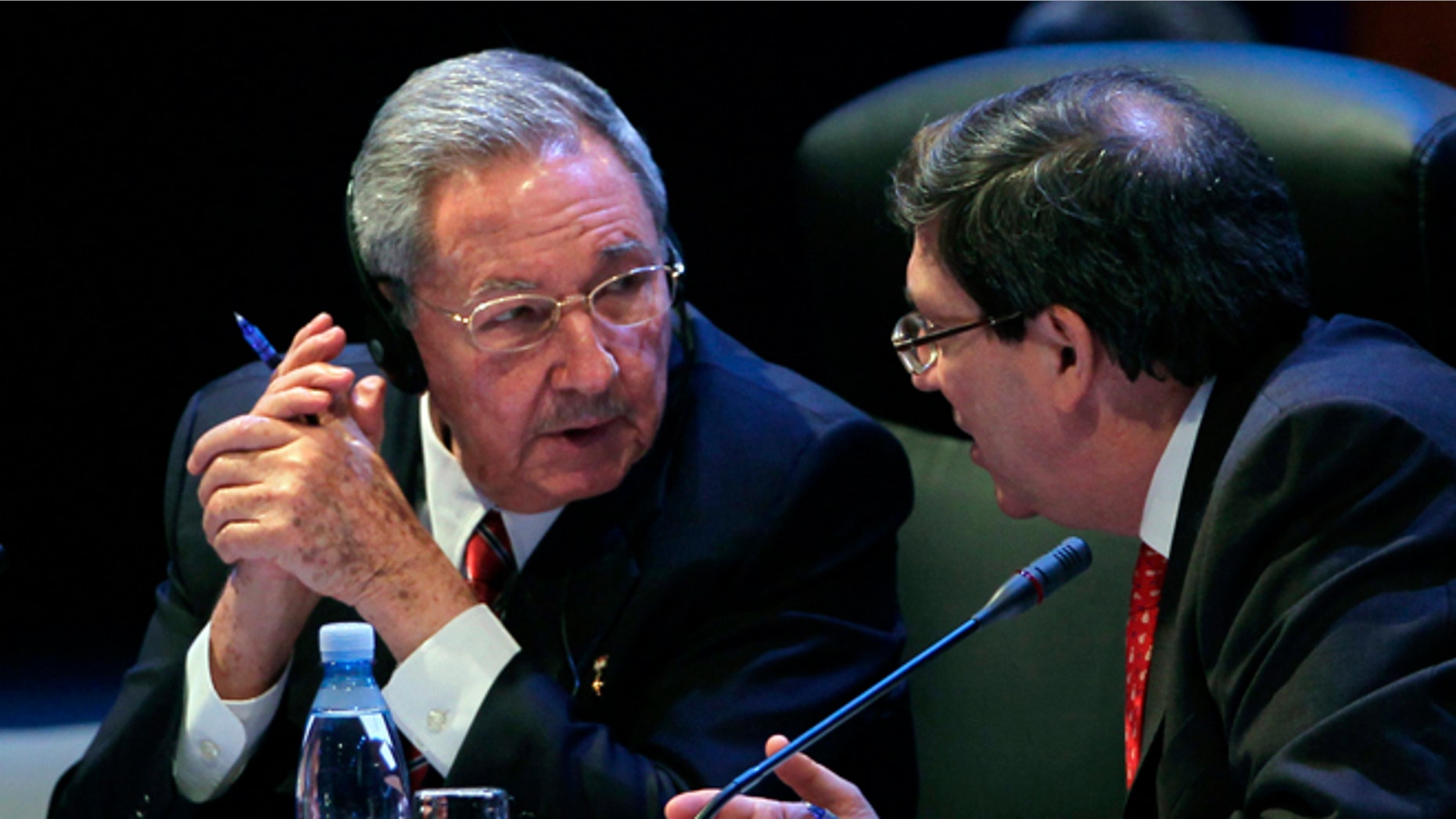 Cuba's President Raul Castro speaks to his Foreign Minister Bruno Rodriguez during a session of the CELAC Summit in Havana, Cuba, Tuesday, Jan. 28, 2014. Leaders from Latin America and the Caribbean are in Cuba to talk about poverty, inequality and hunger at the summit of the Community of Latin American and Caribbean States, or CELAC. (AP Photo/Cubadebate, Ismael Francisco)