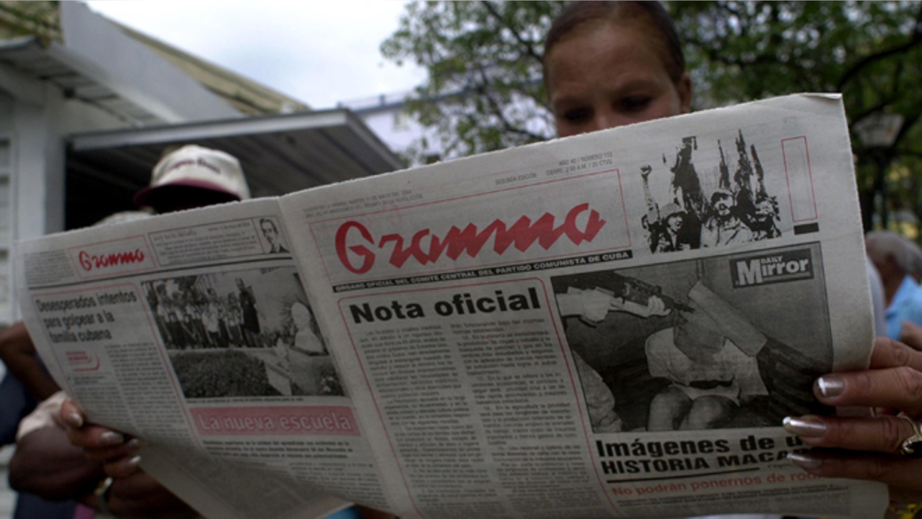 HAVANA, CUBA - MAY 11: A woman reads the official newspaper of the Cuban Communist Party May 11, 2004 in Havana, Cuba. President Fidel Castro's government announced the suspension of most goods bought with US dollars. Castro blamed the new measure on the Bush Administration's decision last week to tighten trips and cash remittances to the island. (Photo by Jorge Rey/Getty Images)