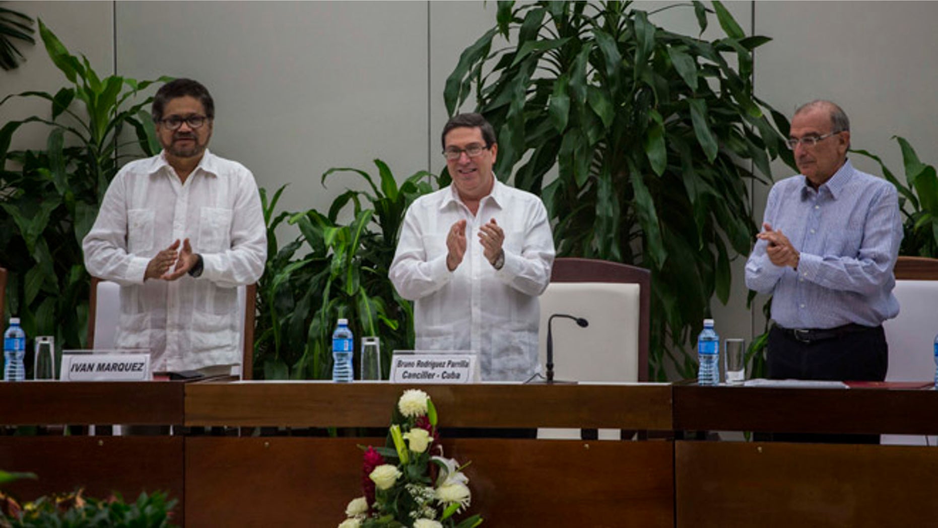 Ivan Marquez, chief negotiator of the Revolutionary Armed Forces of Colombia, or FARC, from left, Cuba's Foreign Minister Bruno Rodriguez, and Humberto de La Calle, head of Colombia's government peace negotiation team, applaud after the signing of the latest text of the peace accord between the two sides in Havana, Cuba, Saturday, Nov. 12, 2016. Colombia's government and the FARC signed a new, modified peace accord on Saturday following the surprise rejection of an earlier deal by voters in a referendum. (AP Photo/Desmond Boylan)