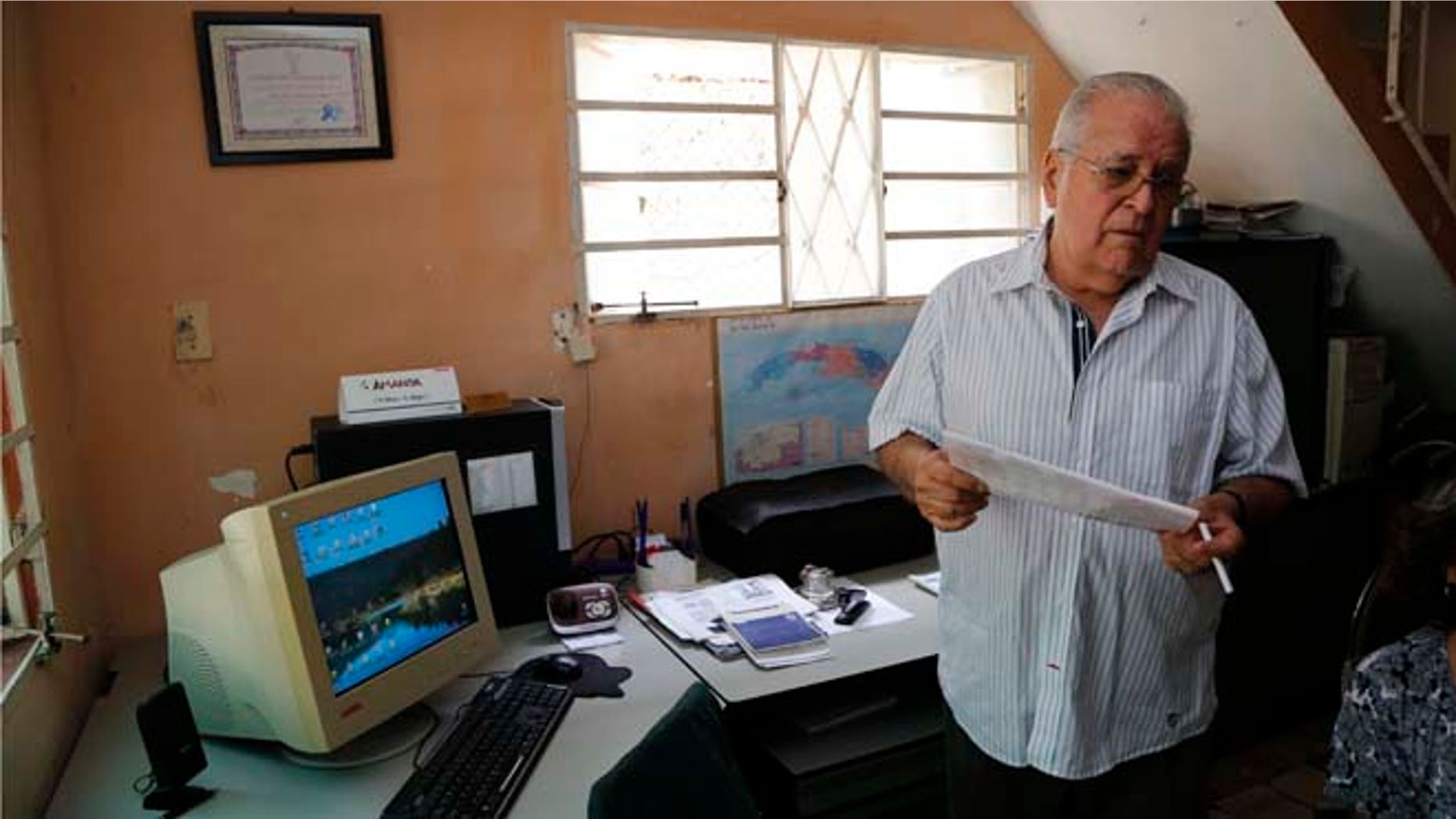 In this July 2, 2015 photo, dissident Elizardo Sanchez, president of the Cuban Commission for Human Rights and National Reconciliation, stands in his home in Havana, Cuba. Many of the dissidents are feeling increasingly sidelined and abandoned as both countries celebrate milestones like Monday's opening of embassies in Havana and Washington. (AP Photo/Desmond Boylan)
