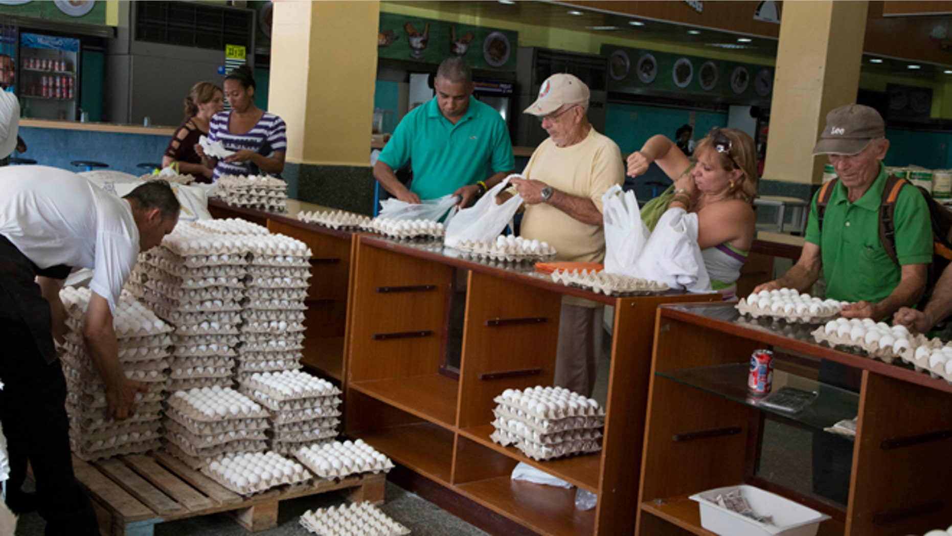 People buy eggs at a a store in Havana, Cuba, Friday, March 20, 2015. More than a dozen Cuban officials have been sentenced to between five and 15 years in prison in connection with what authorities call a scheme to divert millions of eggs to the black market. (AP Photo/Desmond Boylan)