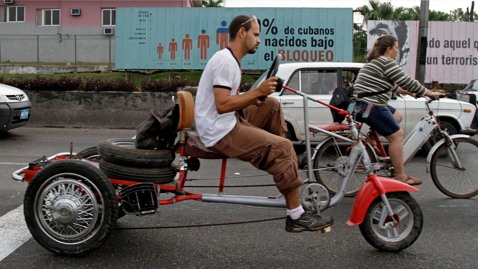 Commuters ride past a billboard that reads in Spanish; "70 percent of Cubans have been born under the Embargo," in Havana, Cuba, Tuesday Feb. 7, 2012. The United States economic embargo on Communist-run Cuba turned 50 on Tuesday. (AP Photo/Franklin Reyes)