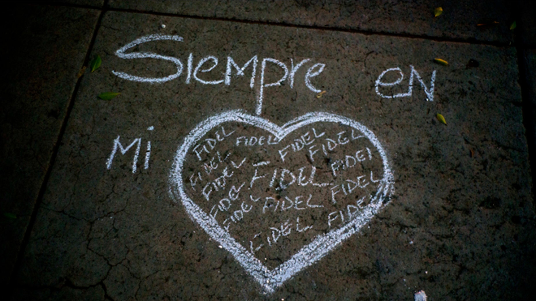 A heart and the text that reads in Spanish "Always in my heart Fidel" are outlined in chalk on a sidewalk, during a vigil at the university where the late Cuban leader Fidel Castro studied law as a young man in Havana, Cuba, Saturday, Nov. 26, 2016. Castro, who led a rebel army to improbable victory in Cuba, embraced Soviet-style communism and defied the power of U.S. presidents during his half century rule, died at age 90. (AP Photo/Ramon Espinosa)
