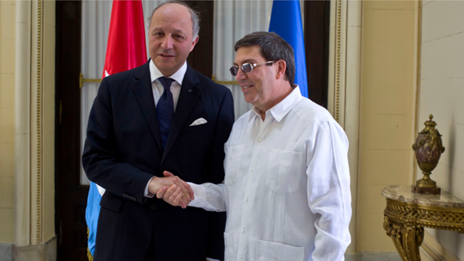 April 12, 2014: Cuba's Foreign Minister Bruno Rodriguez, right, and France's Foreign Minister Laurent Fabius shake hands toward photographers prior to their meeting at the Foreign Ministry in Havana, Cuba. (AP Photo/Ramon Espinosa)
