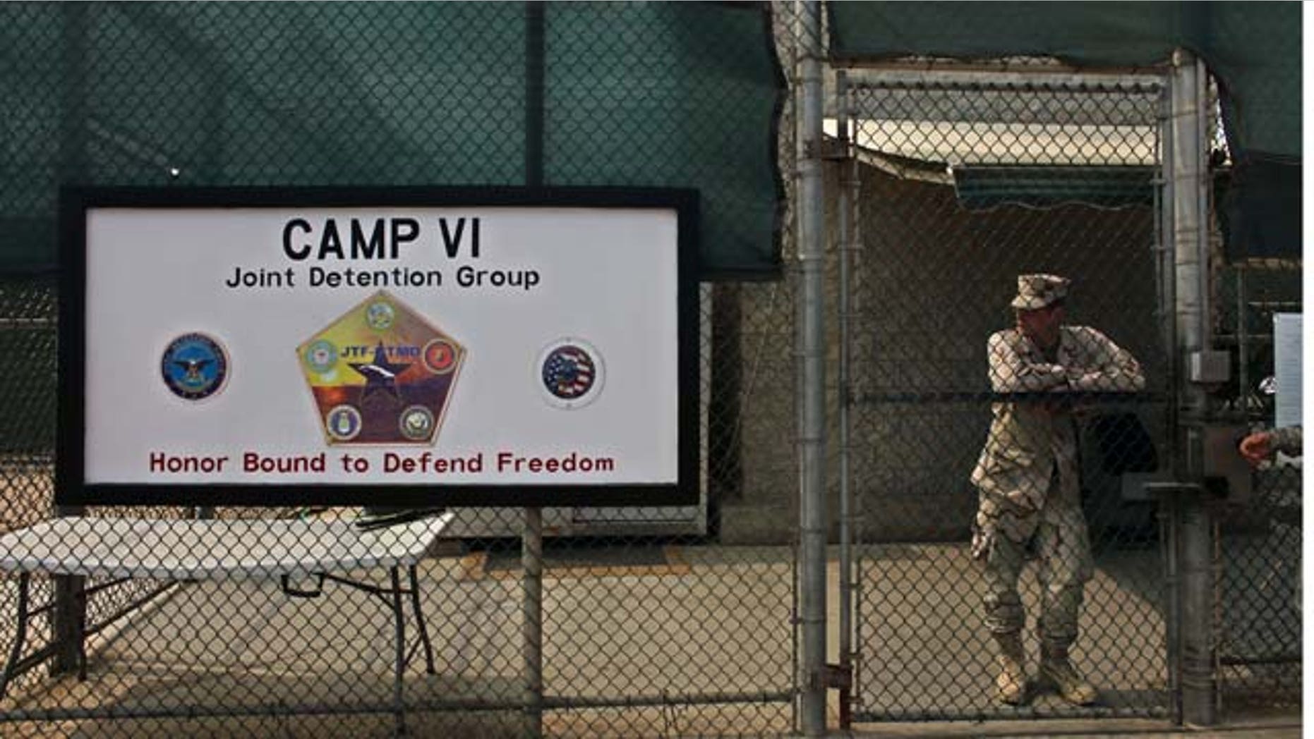 In this file photo taken Tuesday May 12, 2009 and reviewed by the U.S. military, a soldier stands guard at the front gate entrance to the Camp 6 maximum-security detention facility, at Guantanamo Bay U.S. Naval Base, Cuba. (AP)