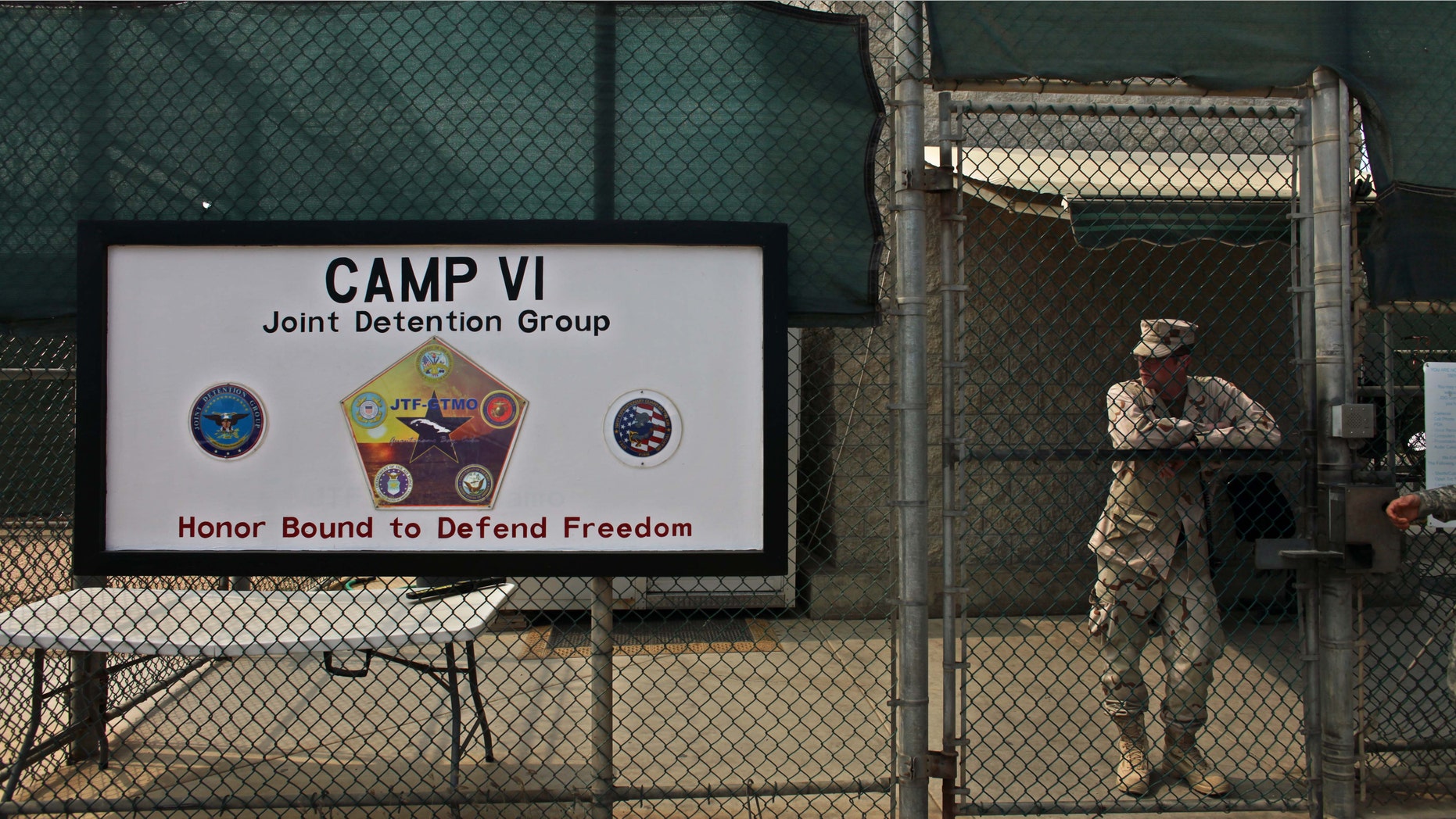 FILE - In this file photo taken Tuesday May 12, 2009 and reviewed by the U.S. military, a soldier stands guard at the front gate entrance to Guantanamo's Camp 6 maximum-security detention facility, at Guantanamo Bay U.S. Naval Base, Cuba. The U.S. government said Sunday Dec. 7, 2014 six men who have been held more than 12 years at Guantanamo Bay have been sent to Uruguay to be resettled as refugees. (AP Photo/Brennan Linsley, File)
