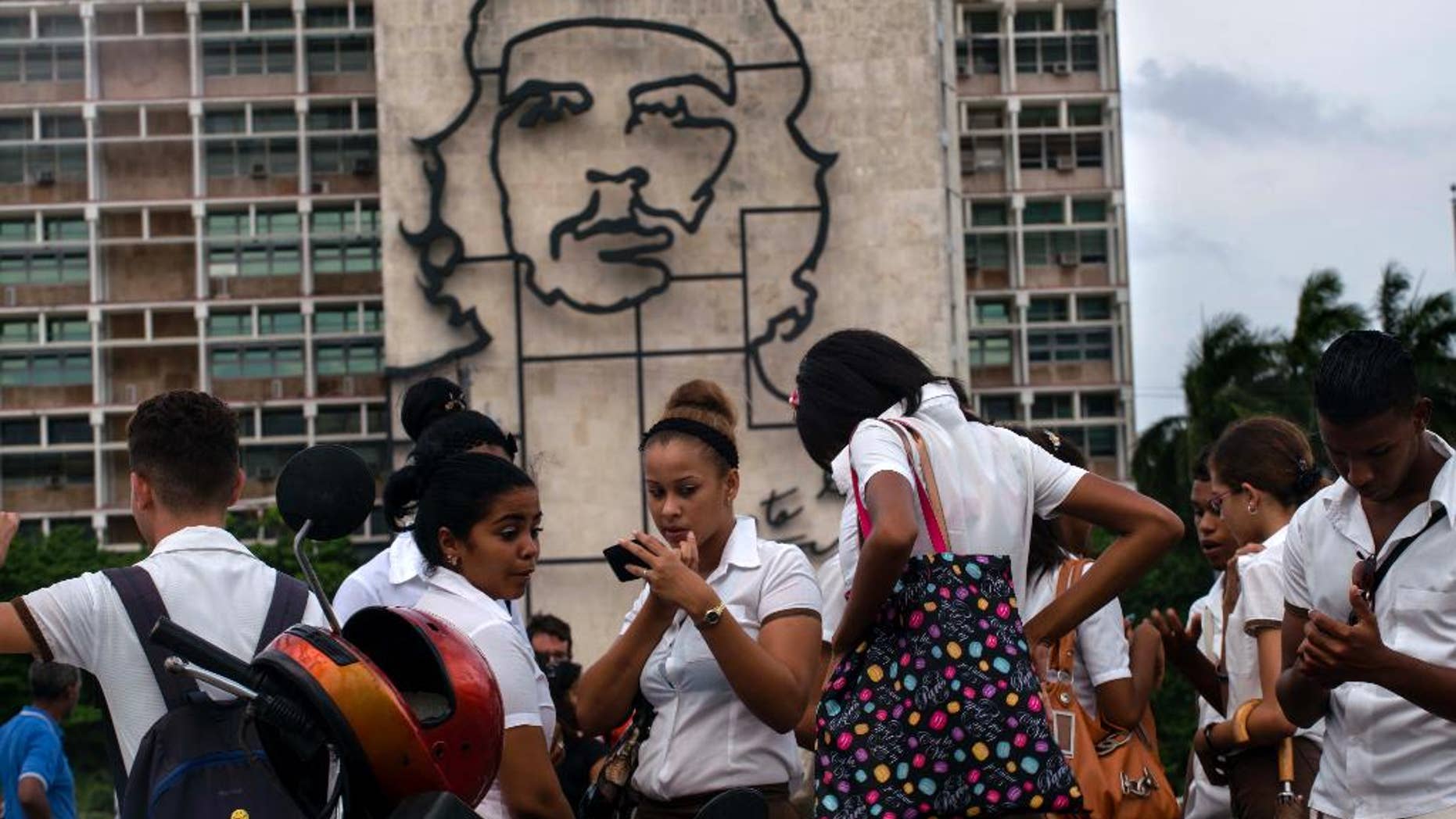 Students stand in Revolution Square next to the sculpture of revolutionary hero Ernesto "Che" Guevara, where the Pope Francis will give a Mass next Sunday in Havana, Cuba,Thursday, Sept. 17, 2015. (AP Photo/Ramon Espinosa)