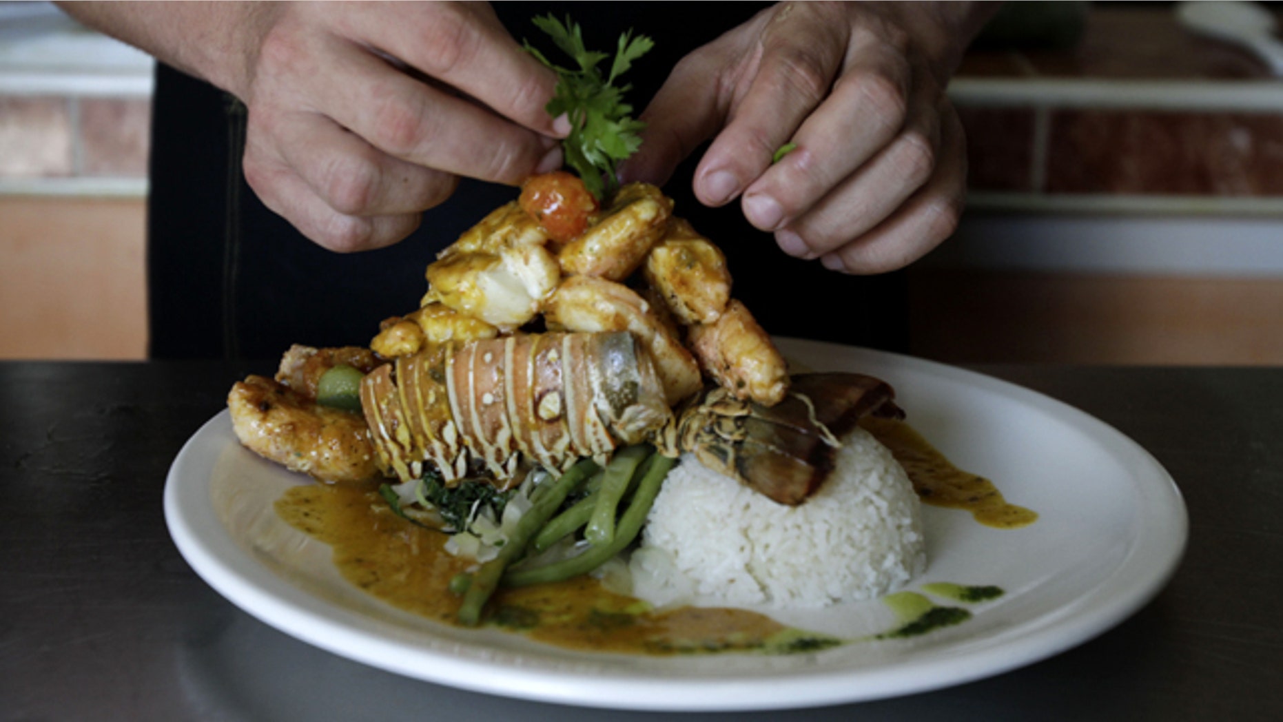 In this photo taken Friday, April 29, 2011, chef Diomer Matos prepares "Esclava de Langosta," a lobster dish, at La Moneda Cubana, a private restaurant, in Old Havana, Cuba. A restaurant boom is sweeping Havana under new rules that make it easier to run "paladars," with a wave of new private eateries opening since January 2011. (AP Photo/Franklin Reyes)