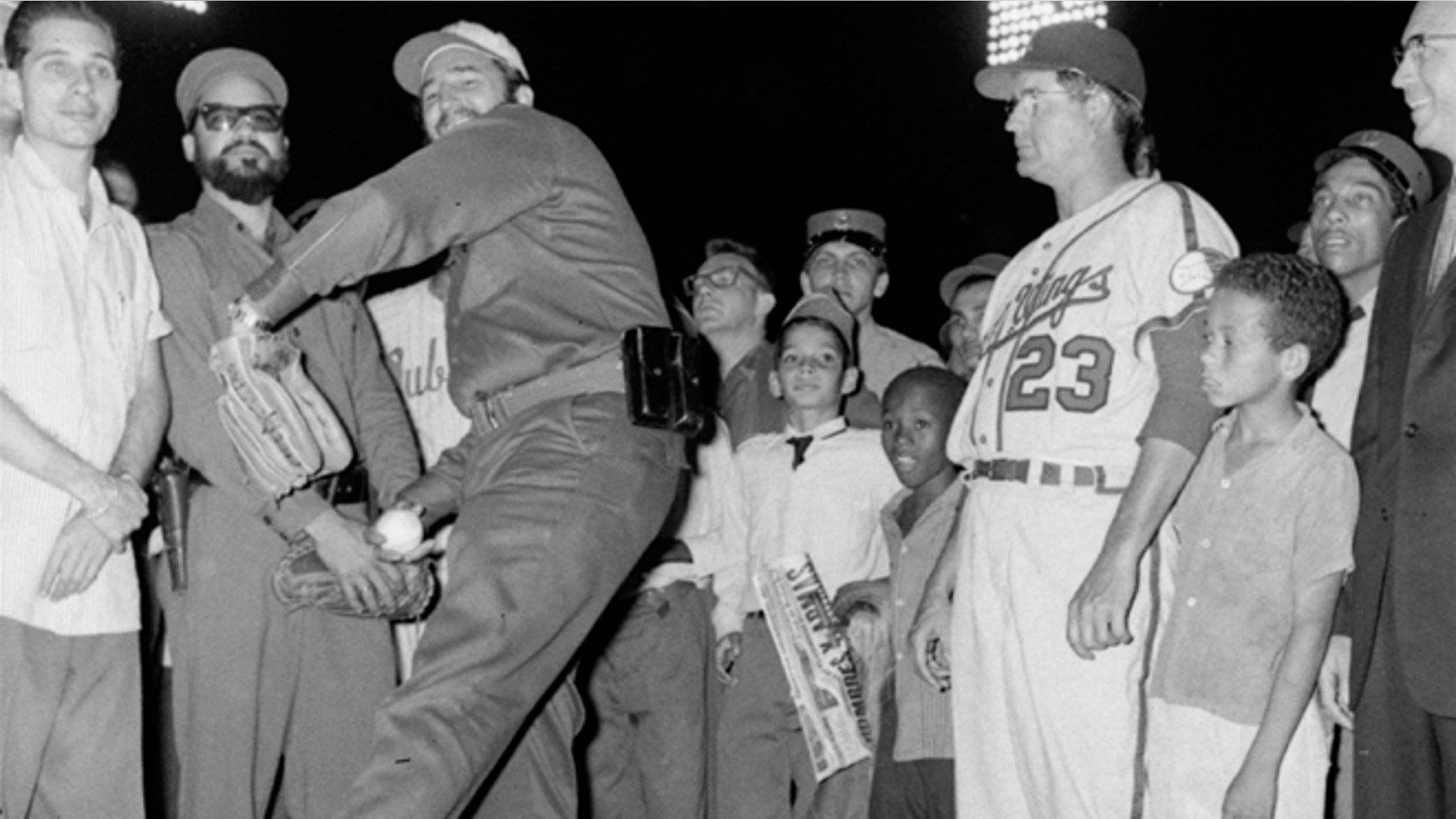 FILE - In this April 20, 1960, file photo, Cuban leader Fidel Castro tosses the traditional first ball at ceremonies opening the International League baseball season, in Havana, Cuba. At right is Rochester Red Wings manager Clyde King, whose Redwings met the 1959 Little World Series champion Havana Sugar Kings, in the season opener. In June, 1960 the Red Wings were the last American ball club to play a regulation game in Cuba until the Baltimore Orioles played an exhibition game in Havana in 1999. It's too soon to tell what impact the normalizing of relations between the U.S. and Cuba might have on the game. (AP Photo/File)