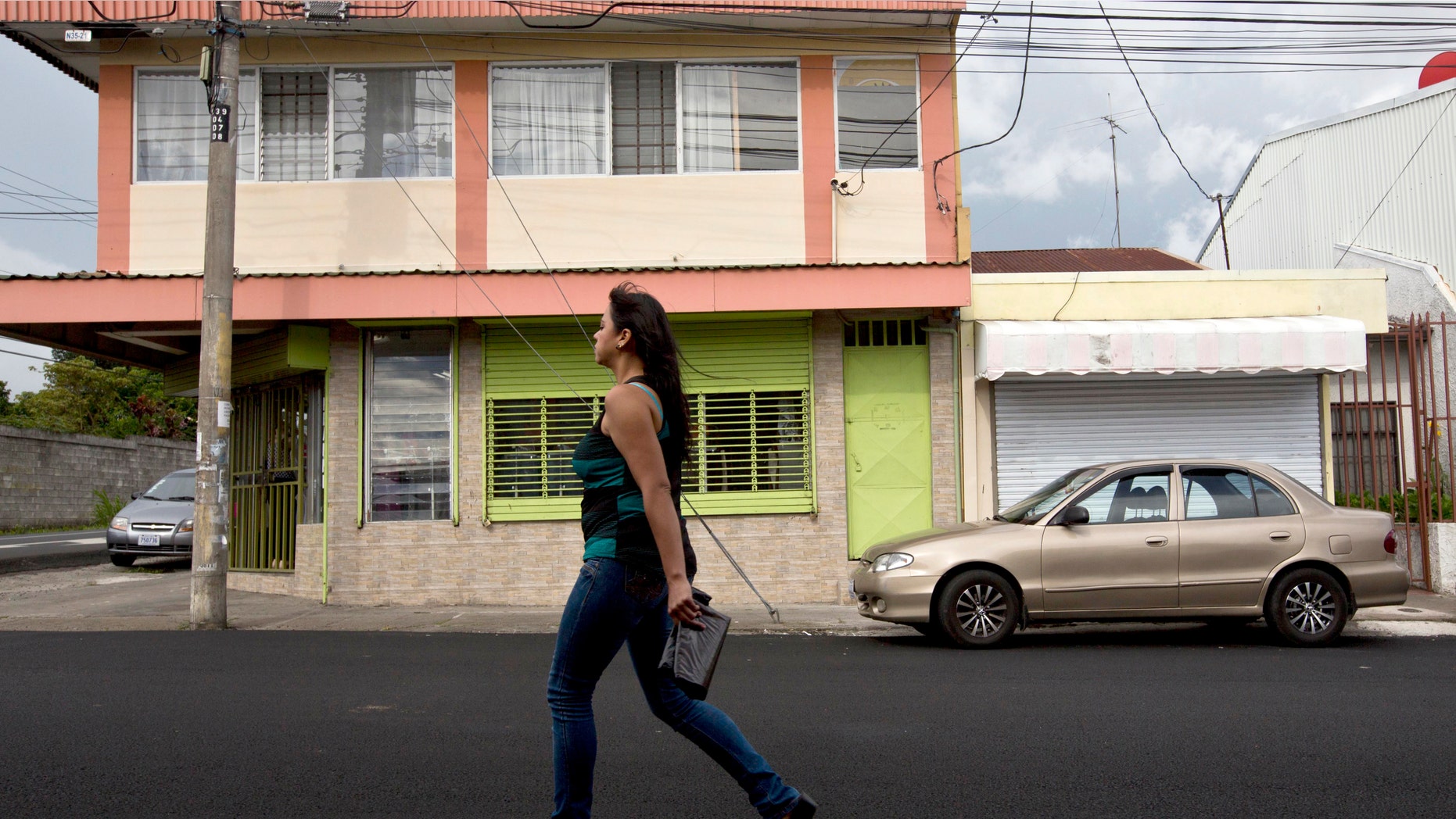A woman walks in front of the building that once housed the human rights group Fundacion Operacion Gaya Internacional in Heredia, Costa Rica. The group and had been contracted by Creative Associates to turn Cubaâs politically apathetic young people into "change agents."