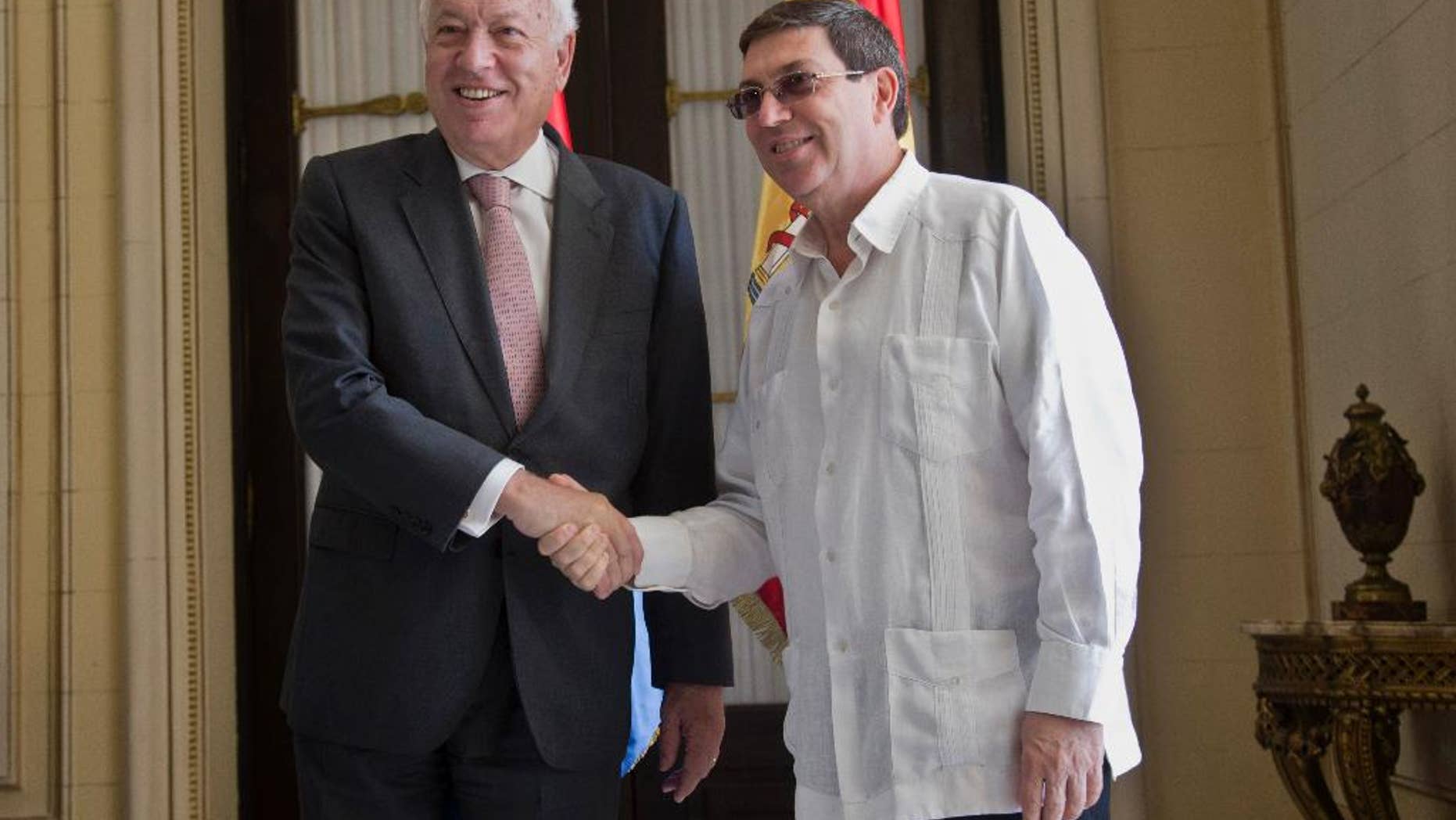 Cuba's Foreign Minister Bruno Rodriguez, right, and Spanish Foreign Minister Jose Manuel Garcia-Margallo pose for a photo prior to their meeting at the Foreign Ministry in Havana, Cuba, Tuesday, Nov. 25, 2014. Margallo is in Cuba on a three-day visit. (AP Photo/Ramon Espinosa)