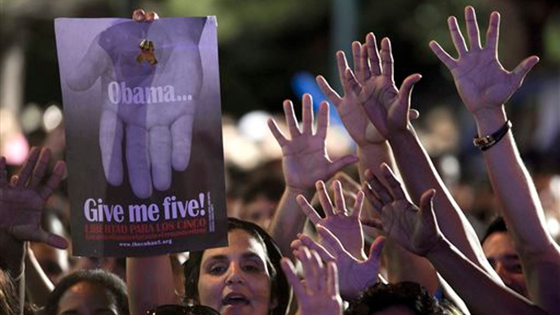 A woman holds a poster that reads "Obama give me five" during a concert in honor of the five intelligence agents in Havana, Cuba, Saturday, March 1, 2014. Thousands of Cubans rallied at the University of Havana on Saturday night for a concert to give a hero's welcome to the second of five intelligence agents to return to the island after completing long prison terms in the United States. (AP Photo/Franklin Reyes)