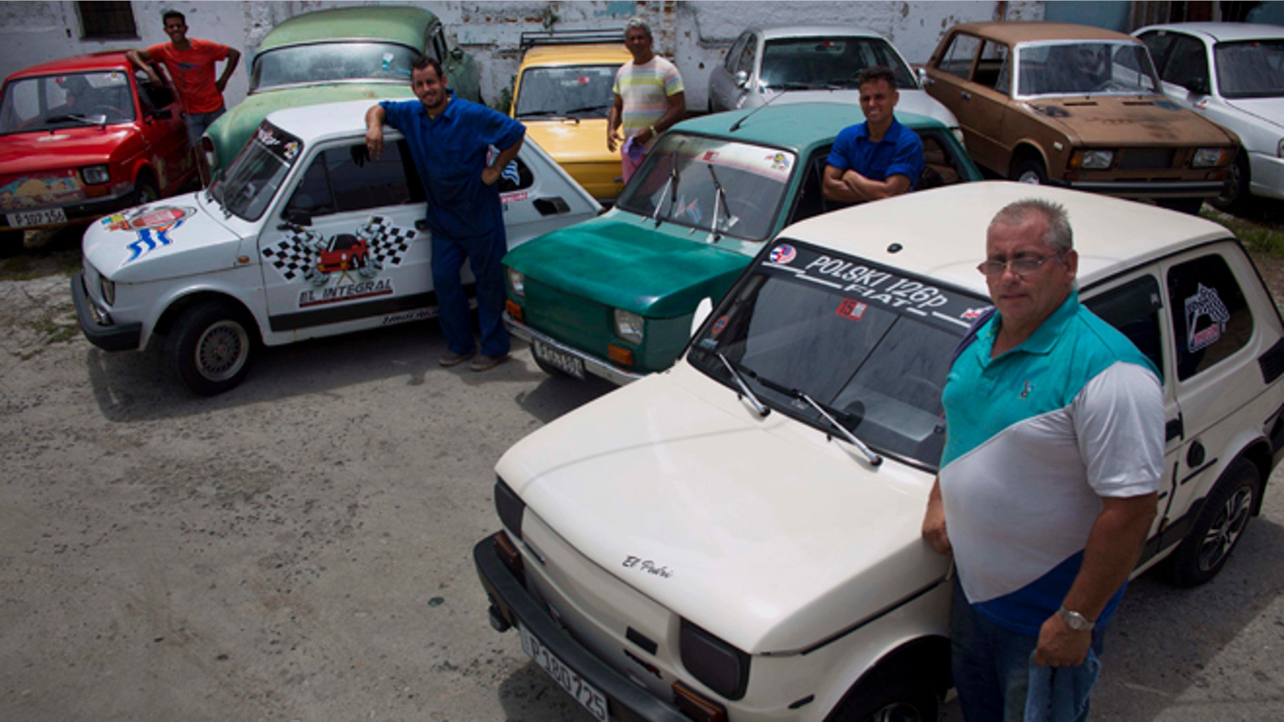 Fiat Polski 126p, owners Raul Seoane, left, Ramses Fernandez, second left, Evilio Aguilar, center, Rigoberto Mesa, second right, and Pedro Fernandez, proudly pose with their cars in Havana, Cuba, Tuesday, August 10, 2016. With around just 24 horsepower, depending on exactly how each one has been altered, the half-ton Polski offers families a shot at independent mobility for a few thousand dollars, a sum within reach of those able to save from private jobs or family sending money from overseas. (AP Photo/Ramon Espinosa)