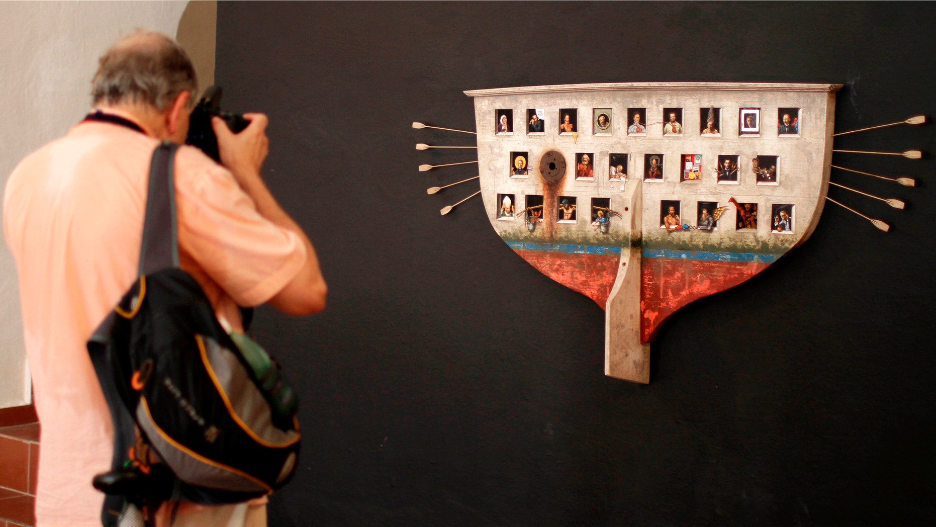 A visitor takes a picture of "My Ark" by Cuban artist Ruben Alpizar at the San Carlos de La Cabana fortress as part of the 11th Havana Biennial exhibition in Havana, Cuba, Friday, May 25, 2012. (AP Photo/Franklin Reyes)