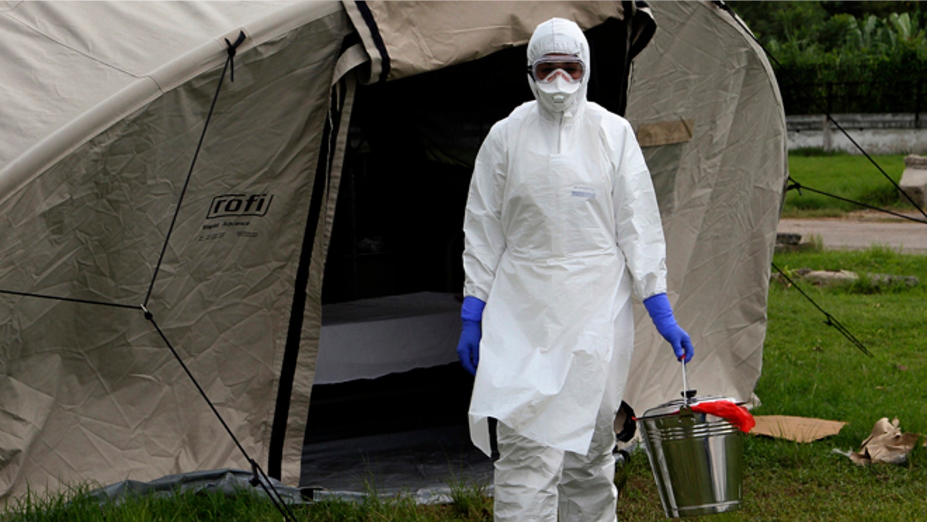 In this Sept. 24, 2014 photo, nurse Dalila Martinez, trainer of the Cuban medical team to travel to Sierra Leone, practices proper disposal at a training camp, in Havana, Cuba. Cuba's health ministry is sending more than 160 health workers to help stop the raging Ebola outbreak in Sierra Leone in early October. They will stay for six months. (AP Photo/Ladyrene Perez, Cubadebate)