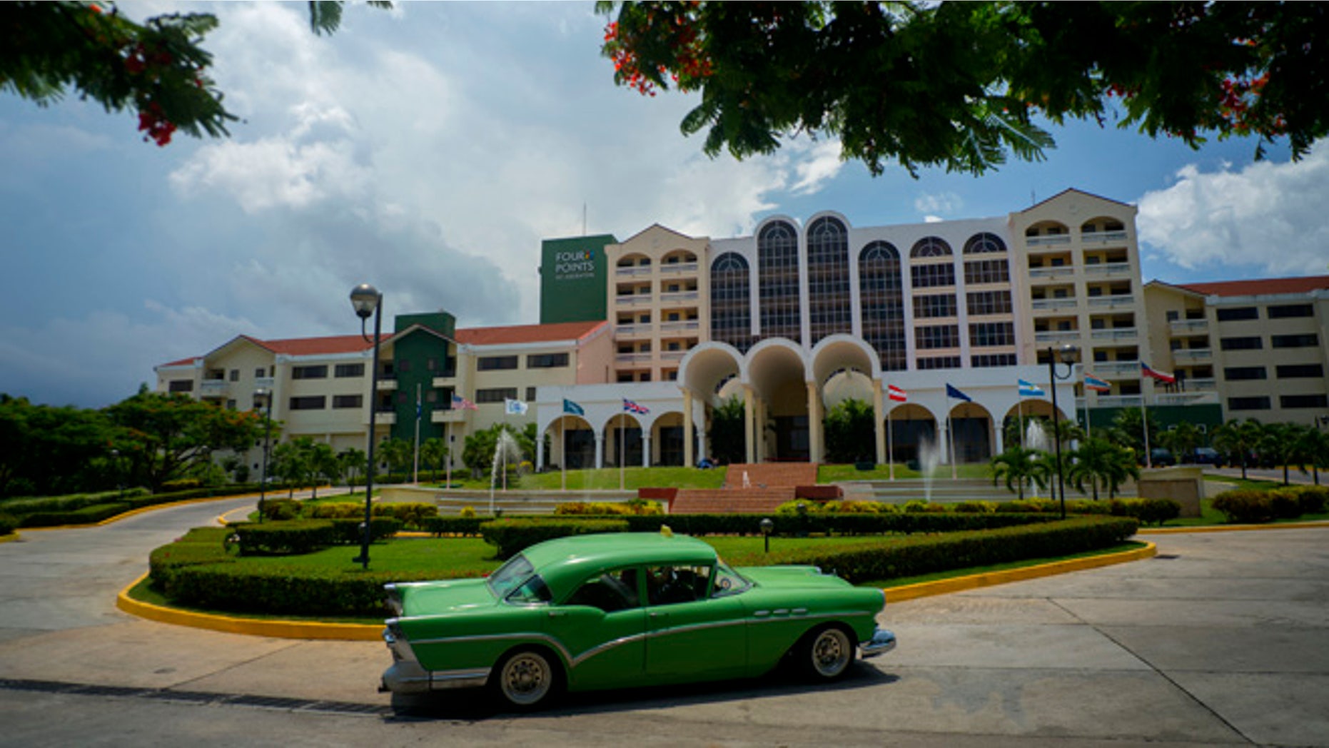 A vintage car passes in front of the Four Points by Sheraton hotel in Havana, Tuesday, June 28, 2016.