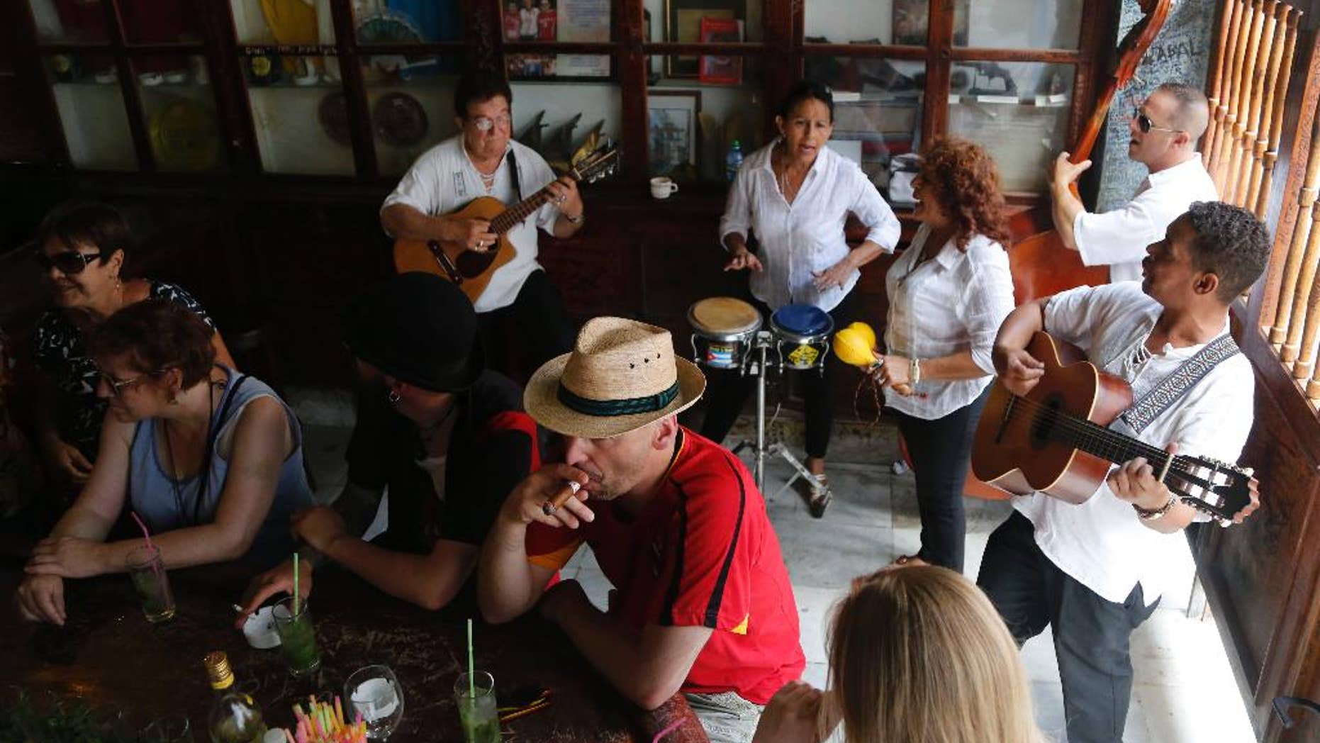 May 24, 2015: Tourists enjoy cigars, mojitos and live music at the Bodeguita del Medio Bar, frequented by the late American novelist Ernest Hemingway in Old Havana, Cuba.