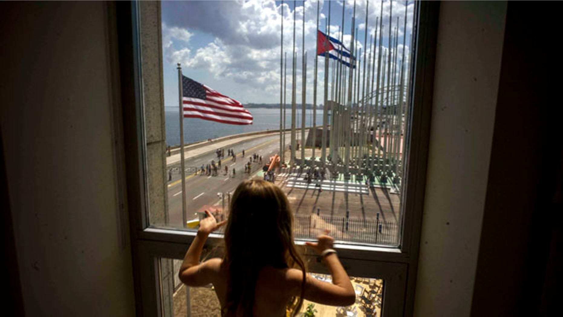 FILE - In this Aug. 14, 2015 file photo, a girl looks out from the newly opened U.S. Embassy after the U.S. flag raising ceremony in Havana, Cuba, as part of officially restored diplomatic relations. U.S. presidential candidate Donald Trump had been generally supportive of the normalization of relations with Cuba, but on Friday, Sept. 16, 2016 the Republican nominee pledged to reverse Obamaââ¬â¢s series of executive orders unless Cuba's President Raul Castro meets demands including ââ¬Åreligious and political freedom for the Cuban people and the freeing of political prisoners." (AP Photo/Ramon Espinosa, File)