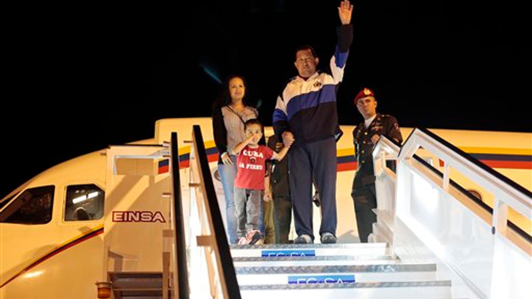 March 31, 2012: Venezuela's President Hugo Chavez waves as he stands with his daughter Rosa Virginia and his grandson Jorge upon arrival to the airport in Havana, Cuba.