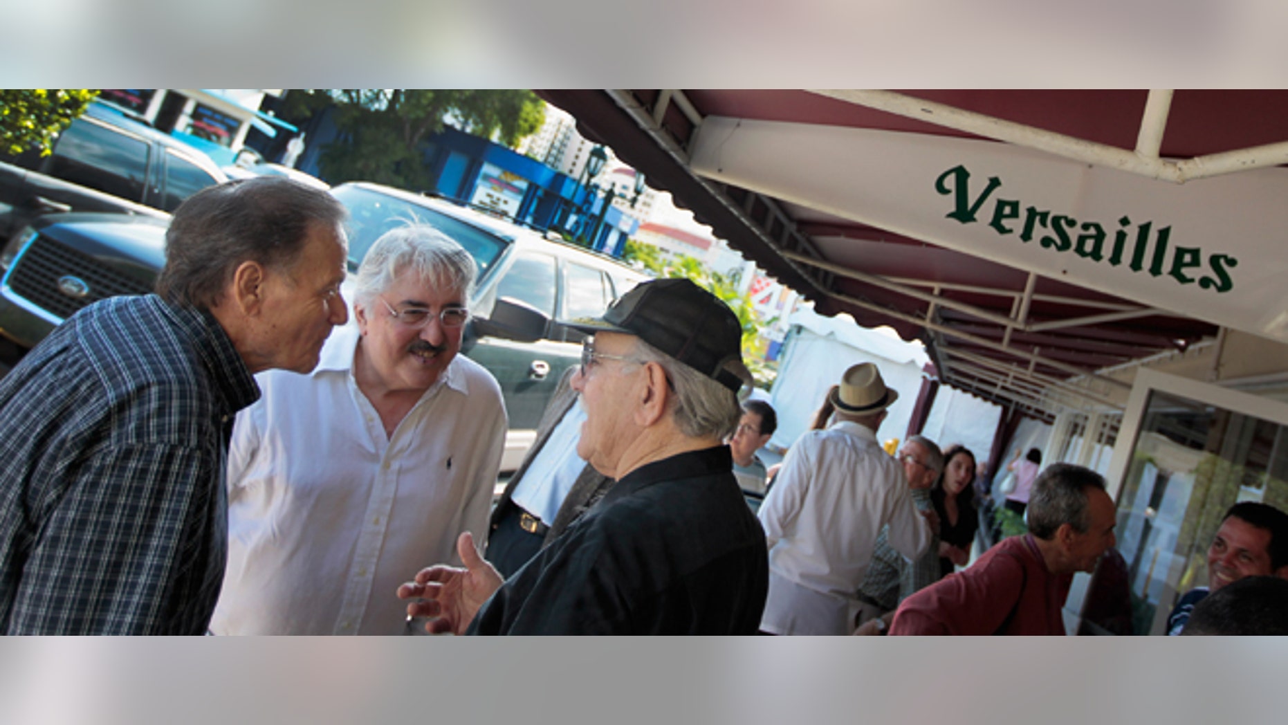 MIAMI, FL - JULY 12: People gather in front of Versailles restaurant during the Cuban restaurants 40th anniversary party on July 12, 2011 in Miami, Florida. The famous restaurant was founded by a Cuban exile and is where people hang out to discuss politics over a Cuban coffee and to see which U.S. president, governors, legislators, mayors and commissioners pass through to court the Cuban vote. (Photo by Joe Raedle/Getty Images)