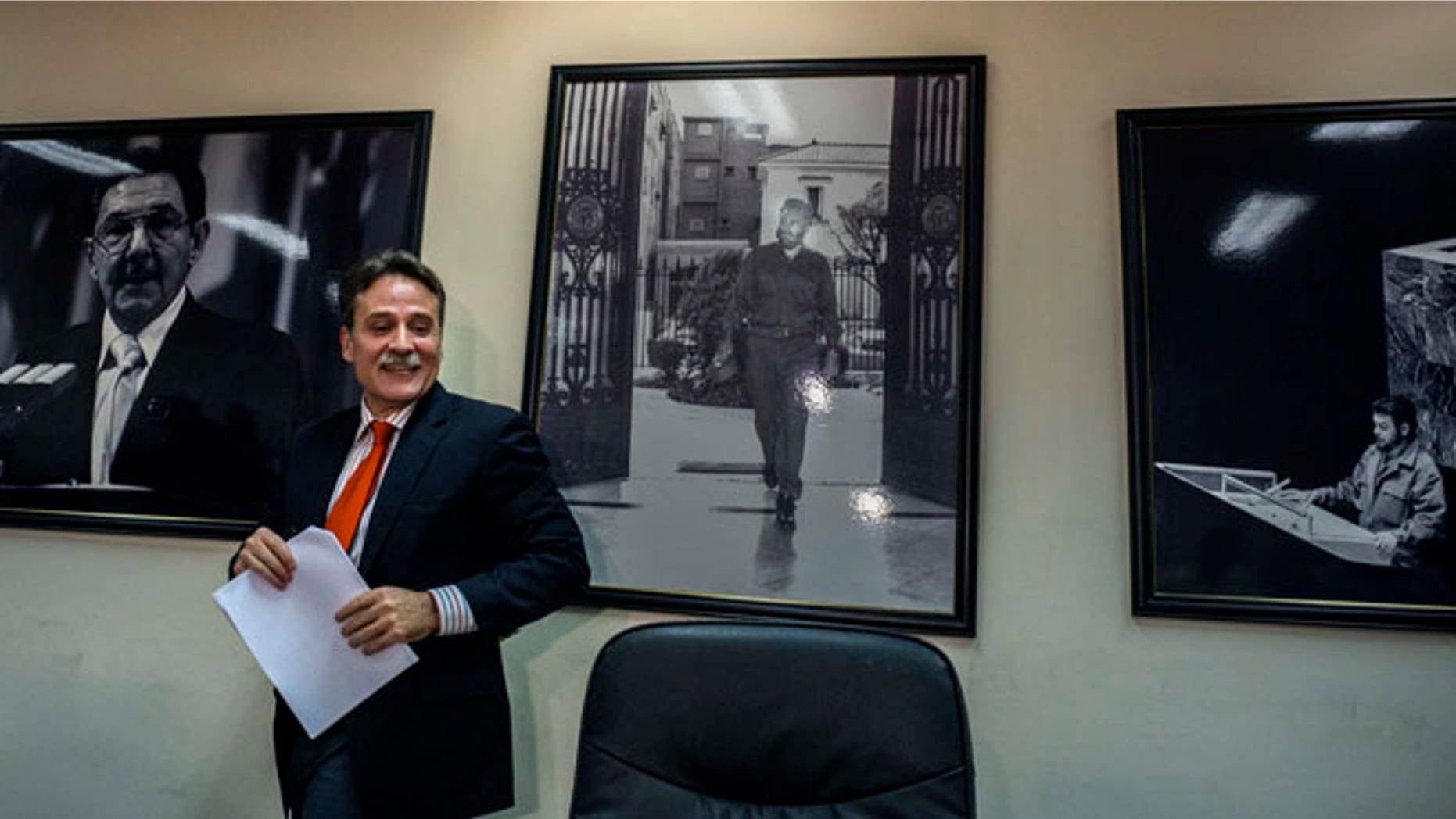 Gustavo Machin, Cuba's deputy chief of North American affairs, speaks to reporters in at the Foreign Ministry in Havana, Cuba, Thursday, May 12, 2016, ahead of Monday's meeting between U.N. representatives from the United States and Cuba. Behind are pictures of Cuba's President Raul Castro, left, his brother Fidel Castro, center, and rebel leader Ernesto "Che" Guevara speaking at the U.N. in 1964. (AP Photo/Ramon Espinosa, Pool)