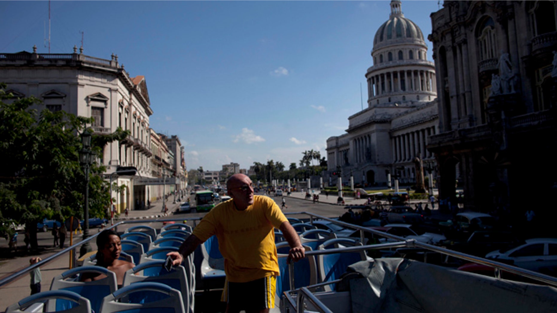 Sept 11, 2012: A tourist stands inside an open-air tourist bus in Havana, Cuba.