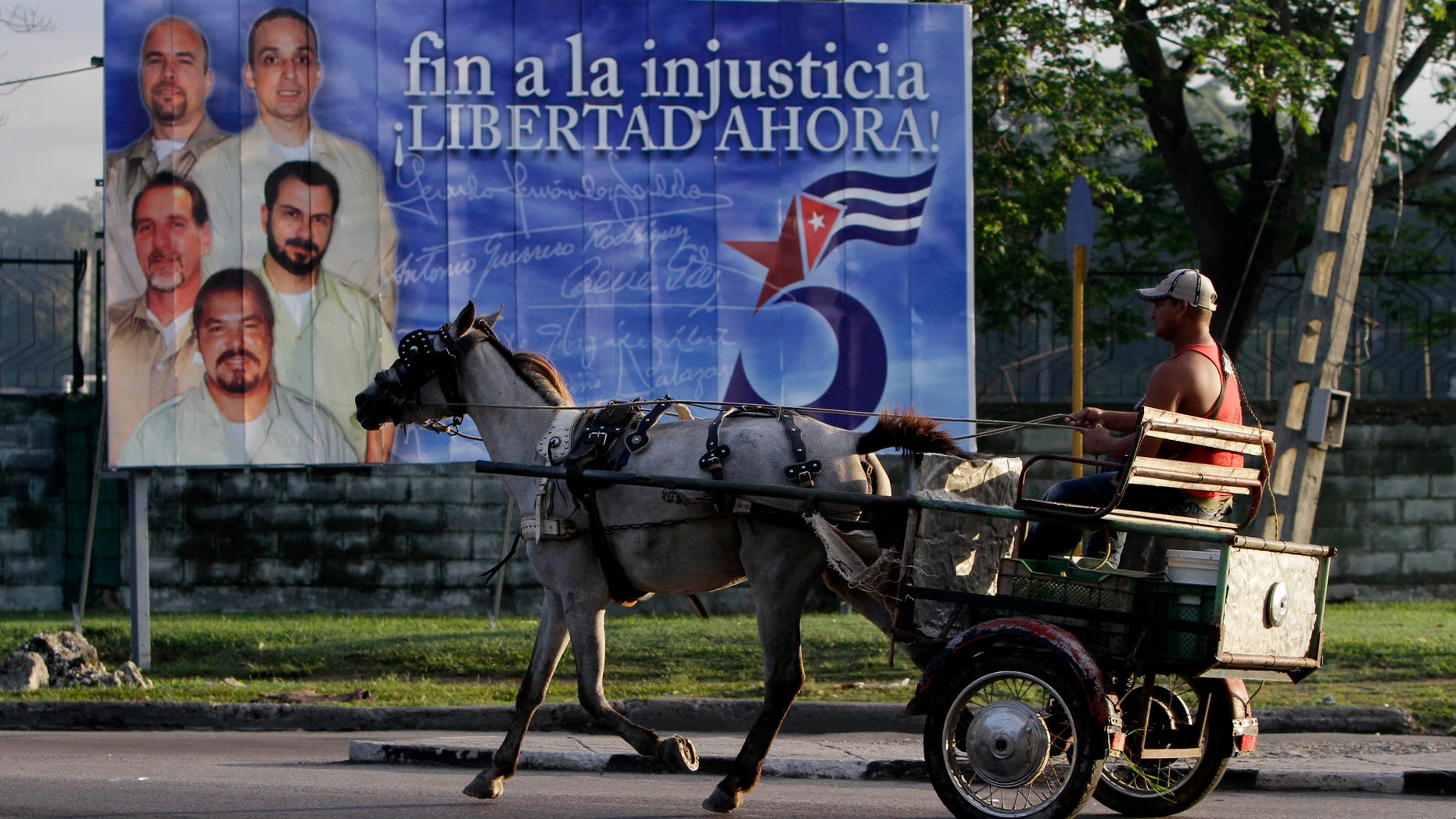 A driver guides his horse drawn carriage past a billboard demanding the freedom of five Cuban intelligence agents imprisoned in U.S., popularly known as the "Cuban Five," in Havana, Cuba.