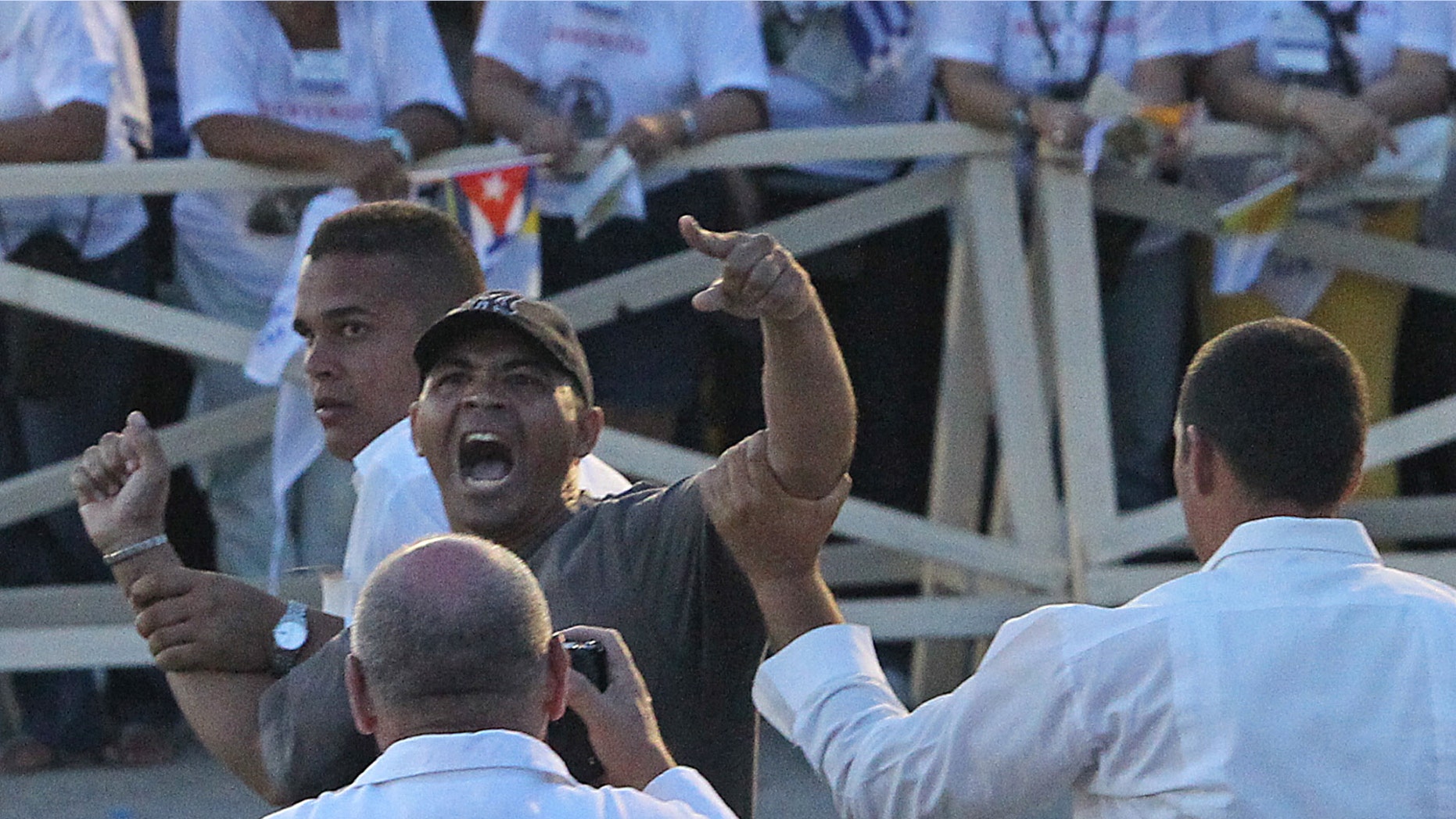 A man who charged through a barricade screaming is rapidly removed by security during a mass by Pope Benedict XVI in the Plaza de la Revolución Antonio Maceo in Santiago, Cuba. Pope Benedict XVI headed to Cuba on Monday, hoping to inspire the same outpouring of faith on the communist-run island as he did in Mexico's conservative Catholic heartland. (AP Photo/The Miami Herald, Patrick Farrell) MAGS OUT