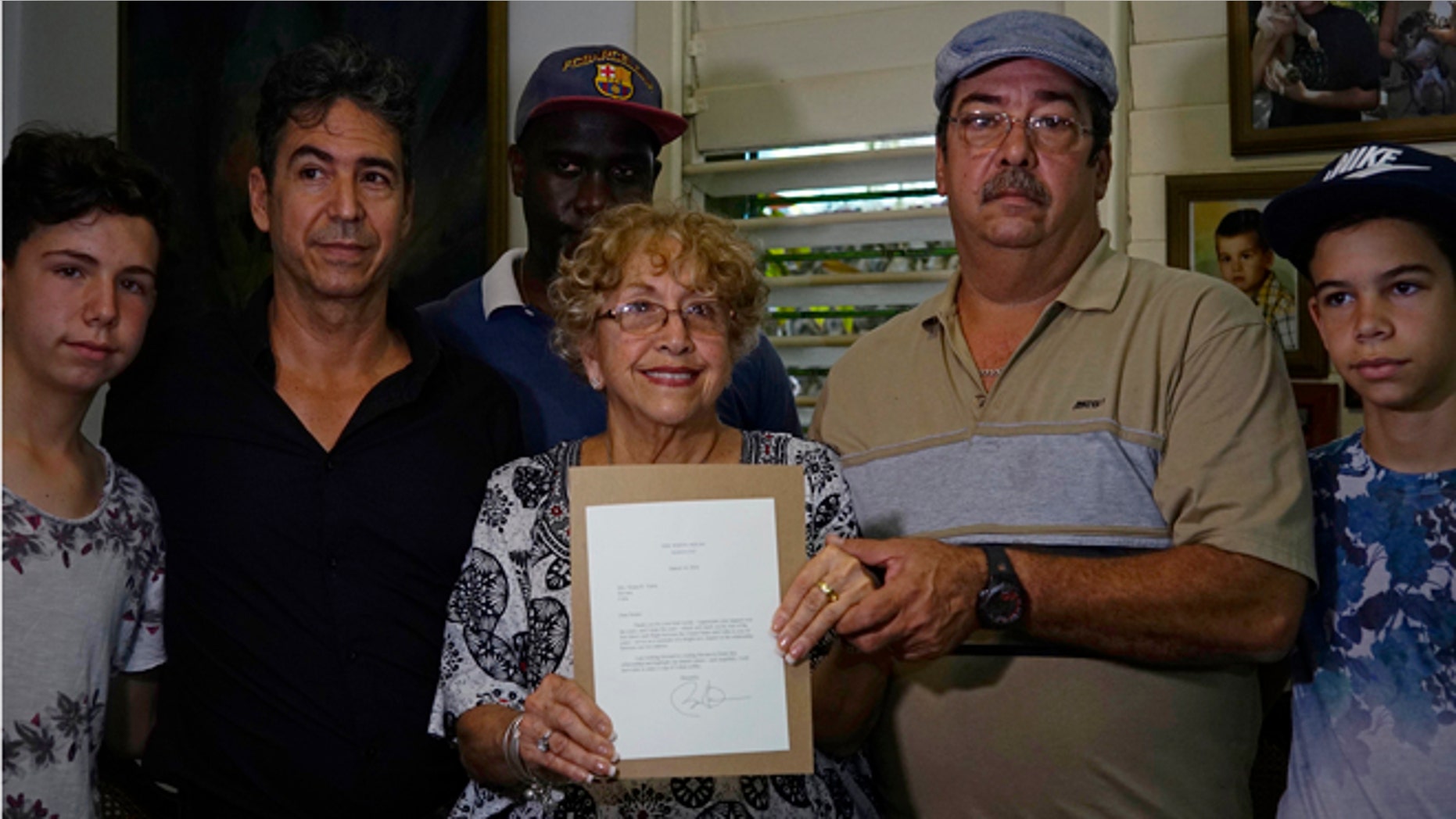 Ileana Yarza surrounded by family, holds a letter by President Obama in Havana, on March 17, 2016.