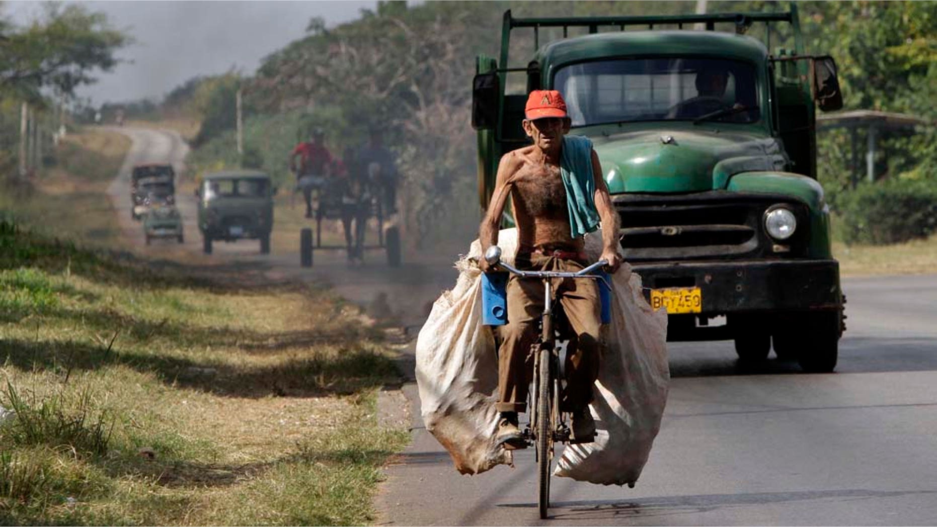 A man carries sacks with beer cans to recycle on his bicycle in Havana, Cuba, Thursday, Jan. 6, 2011. (AP Photo/Franklin Reyes)