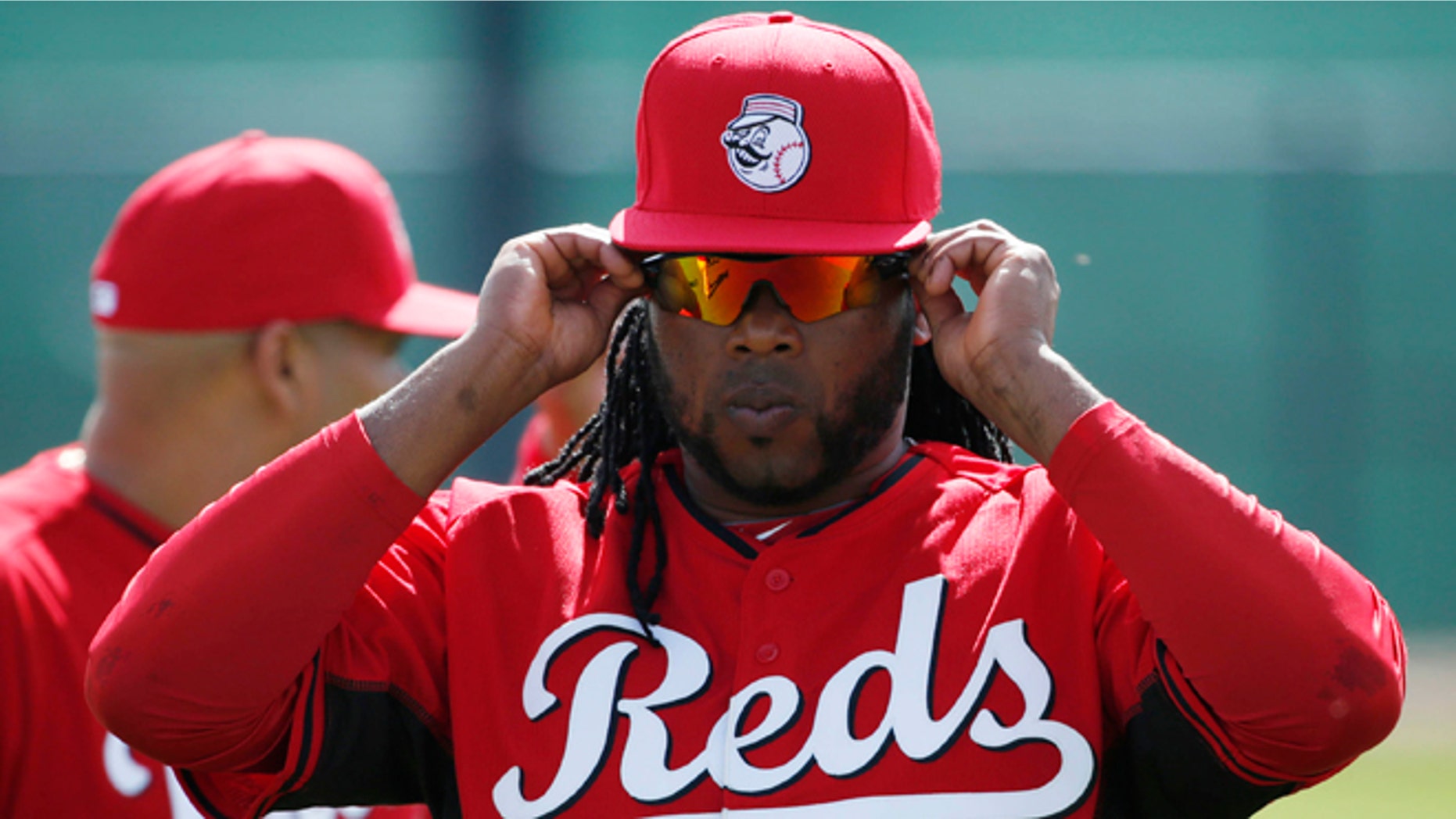 Cincinnati Reds' player Johnny Cueto adjusts his sunglasses during the team's first day of spring training practice Thursday, Feb. 19, 2015, in Goodyear, Ariz. (AP Photo/John Locher)