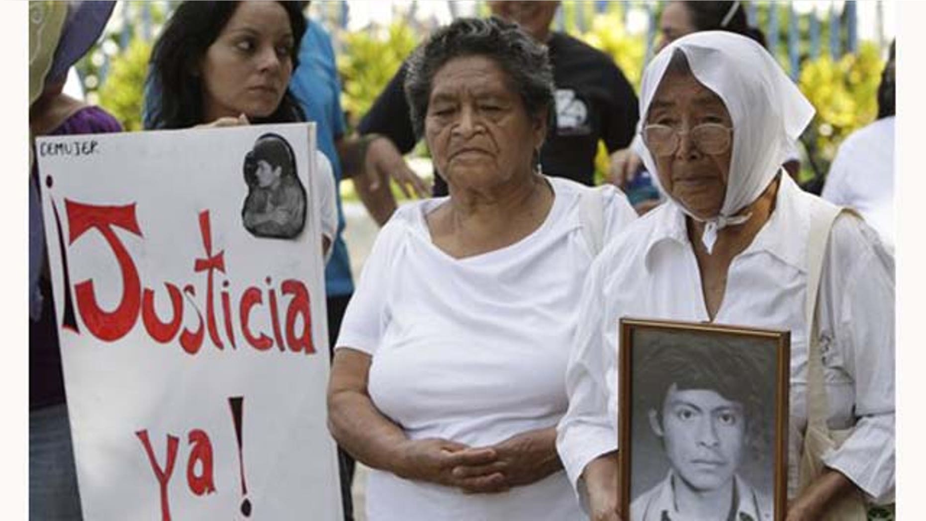 Aug. 17, 2011: Cunegunda Peña holds a photo of her late son Manuel during a protest by the relatives of people who were killed or disappeared during El Salvador's civil war, outside the Supreme Court in San Salvador, El Salvador.