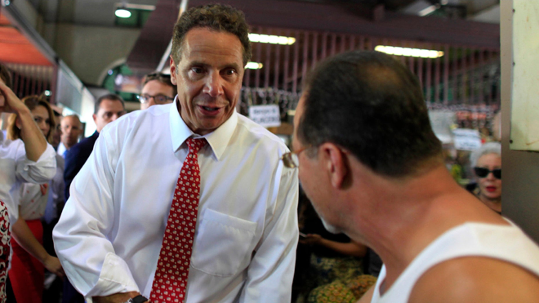New York Gov. Andrew Cuomo greets a bystander during a visit to a local market in San Juan, Puerto Rico, Tuesday, Sept. 8, 2015. Cuomo and a delegation of top state officials met with Puerto Rico's Gov. Alejandro Garcia Padilla, pictured left, on Tuesday to develop what he called a historic partnership with the U.S. territory to help it emerge from a deepening economic crisis. (AP Photo/Ricardo Arduengo)
