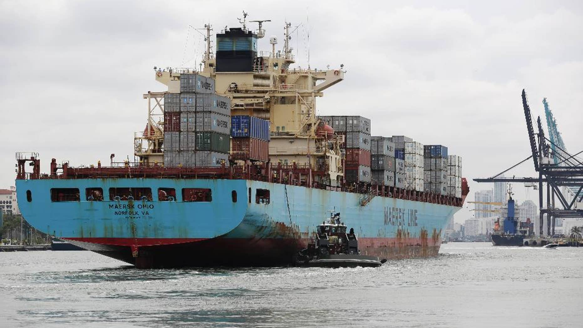 In this Friday, May 16, 2014 photo, a Maersk Line vessel is guided by a tugboat as it heads into the Port of Miami off of Miami Beach, Fla. The Commerce Department reports on the U.S. current account trade deficit for the April-June quarter on Wednesday, Sept. 17, 2014. (AP Photo/Lynne Sladky)