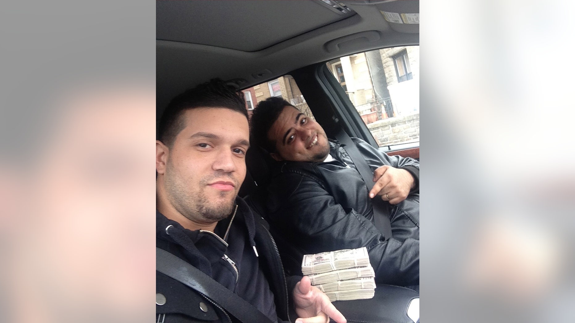 May 9, 2013: In this undated photo provided by the United States Attorneys Office for the Southern District of New York, Elvis Rafael Rodriguez, left, and Emir Yasser Yeje, pose with bundles of cash allegedly stolen using bogus magnetic swipe cards at cash machines throughout New York.