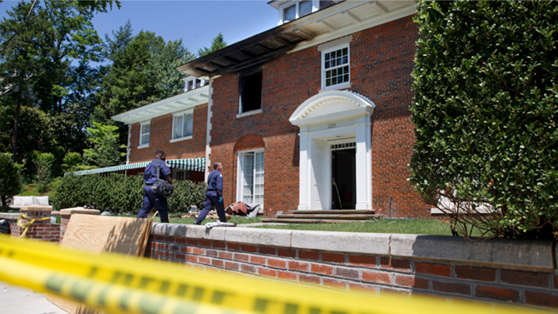 Police continue working at a fire-damaged multimillion-dollar home in northwest Washington home, Friday May 22, 2015, where 46-year-old Savvas Savopoulos, his 47-year-old wife, Amy Savopoulos, the couple's 10-year-old son Philip, and housekeeper Veralicia Figueroa were found dead May 14. U.S. marshals and police arrested a dangerous ex-convict and took his five companions into custody, safely ending a multistate manhunt in the slayings of a wealthy Washington family and their housekeeper. The fugitive task force tracked Daron Dylon Wint to New York and back before they caught up with him late Thursday (AP Photo/Jacquelyn Martin)
