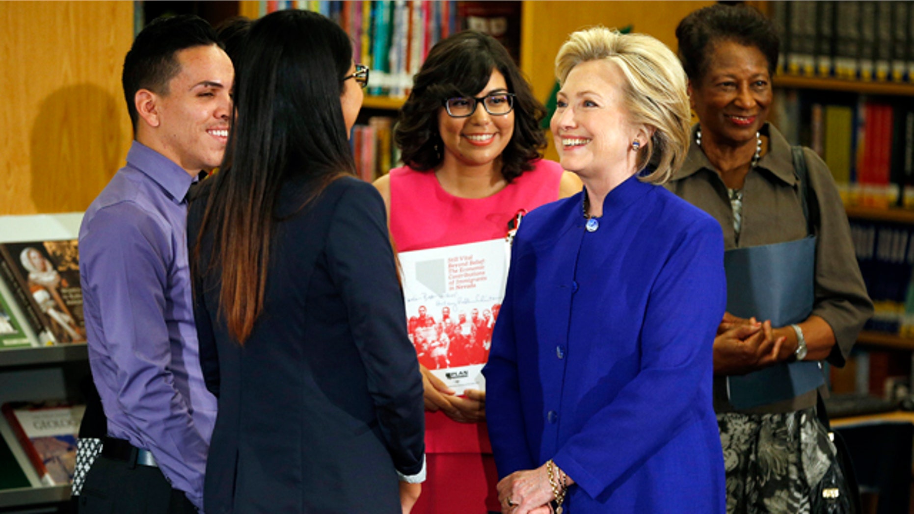 May 5, 2015: Hillary Rodham Clinton, a 2016 Democratic presidential contender, second from right, speaks with a group about immigration at an event at Rancho High School in Las Vegas. (AP Photo/John Locher)