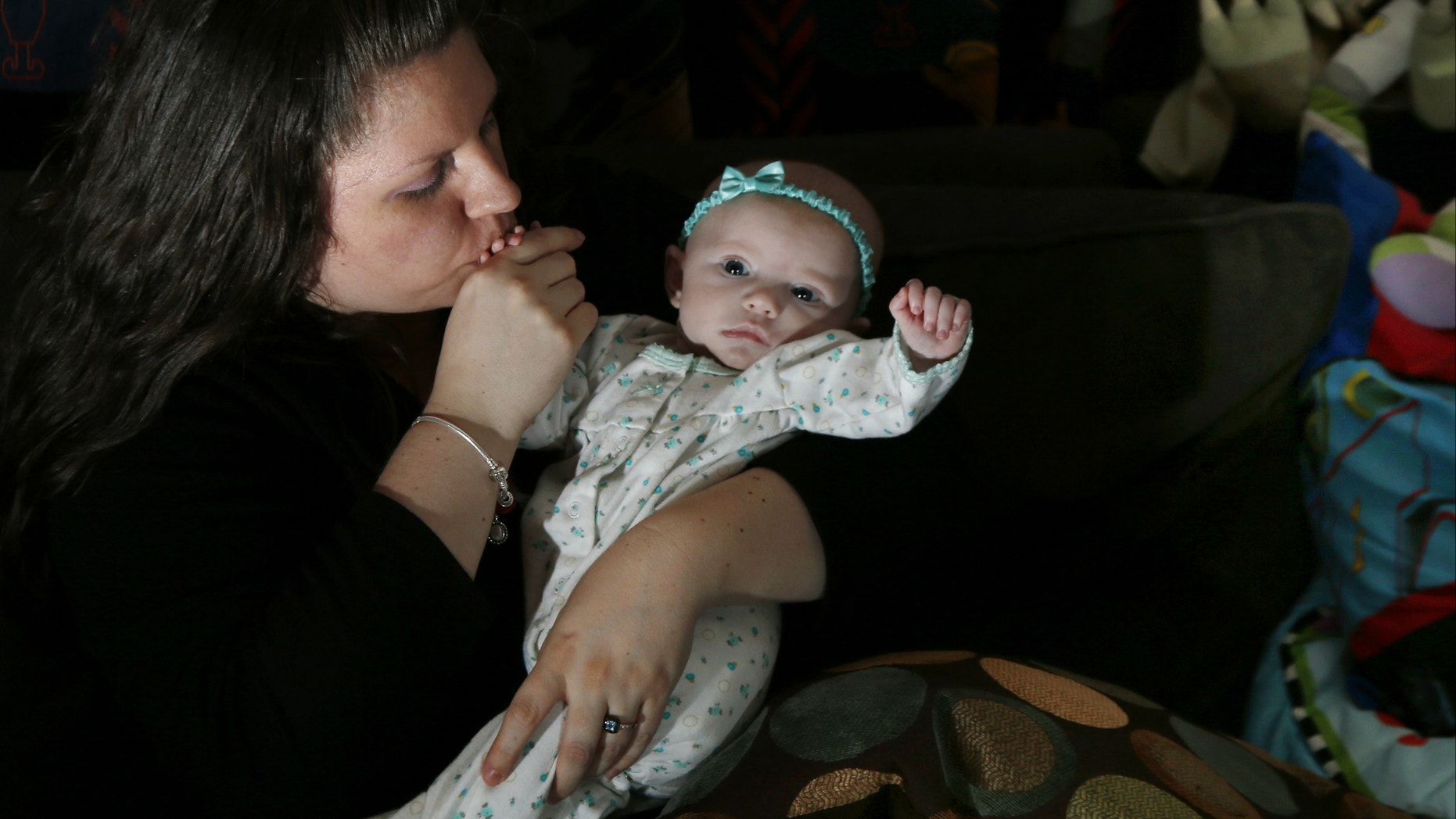 Jennifer Fontaine kisses her baby daughter, Morgan, at her parents' home in Methuen, Mass. After Fontaine's standard prenatal screening suggested her fetus might have Edwards syndrome, a doctor suggested a fetal DNA test, which suggested her fetus was fine.