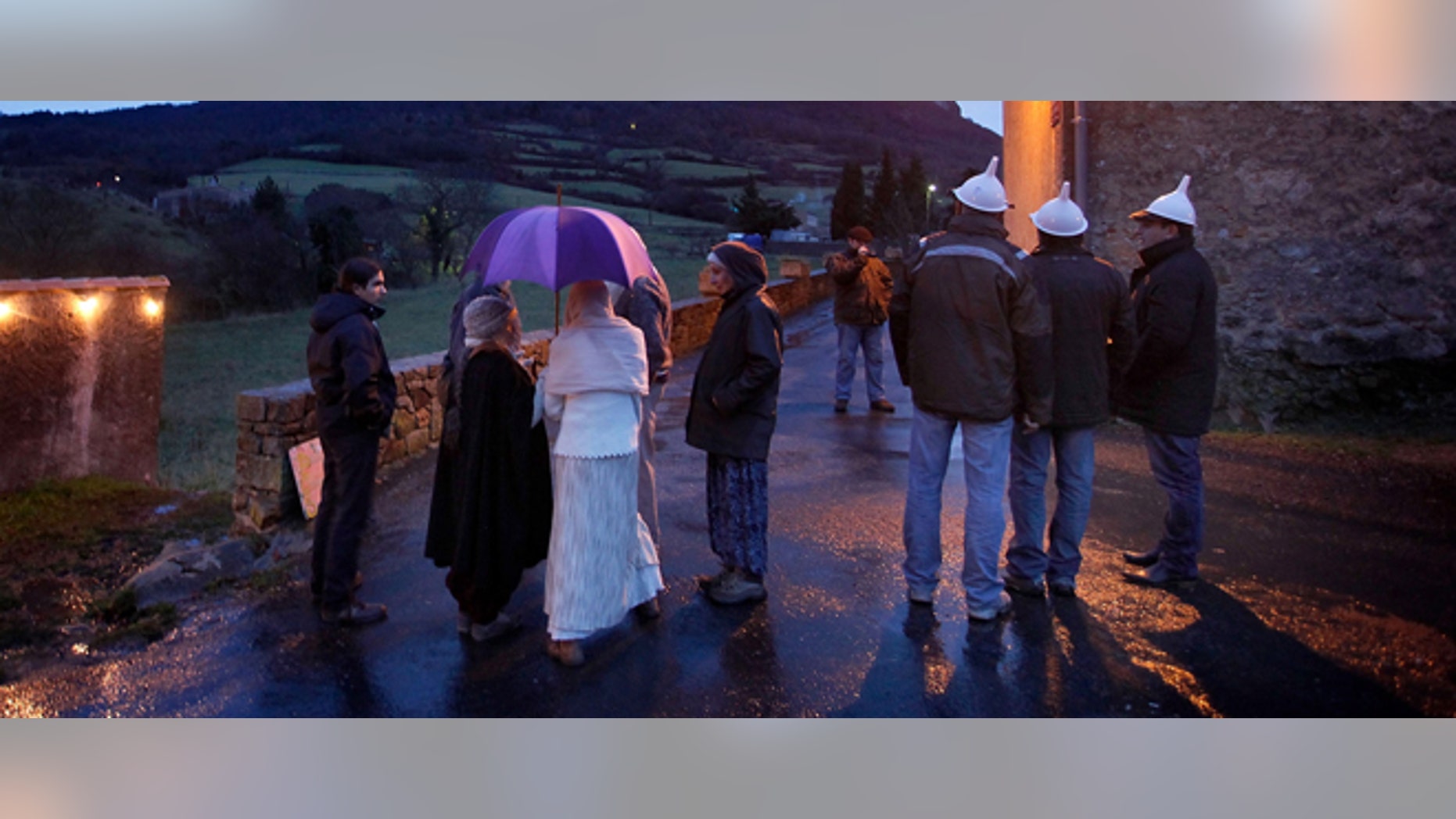 People gather at dusk in Bugarath, a small village in the foothills of the Pyrenees on December 20, 2012 in Bugarach, France.