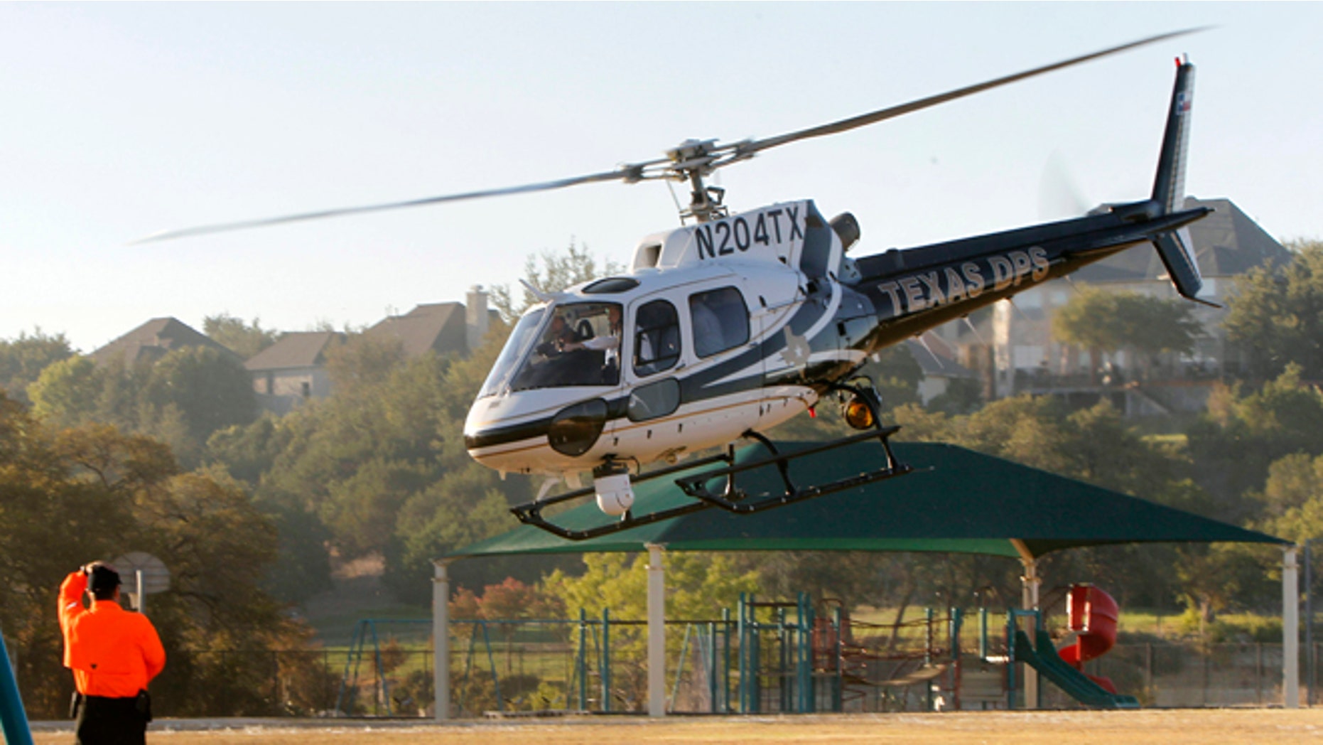 AUSTIN, TX - SEPTEMBER 6: Republican presidential candidate and Texas Gov. Rick Perry takes off aboard a Texas Department of Public Safety helicopter for an aerial tour of the area around Steiner Ranch where homes were destroyed by wildfires the last two days September 6, 2011 in Austin, Texas. Perry, who left his presidential campaign to respond to the fires, said more than 1,000 houses in the area were destroyed. (Photo by Erich Schlegel/Getty Images)