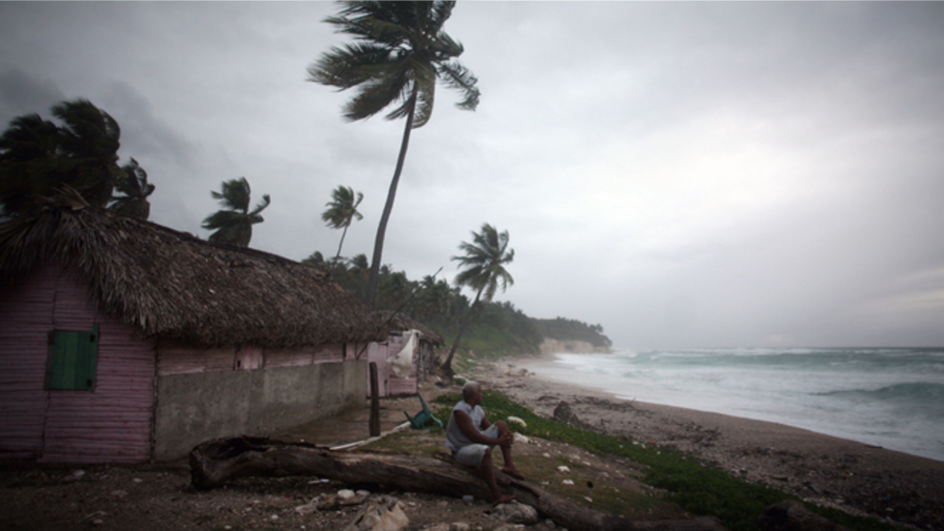 A man look out at the beach as Tropical Storm Isaac approaches in Barahona, Dominican Republic, Friday, Aug. 24, 2012. (AP Photo/Ricardo Arduengo)
